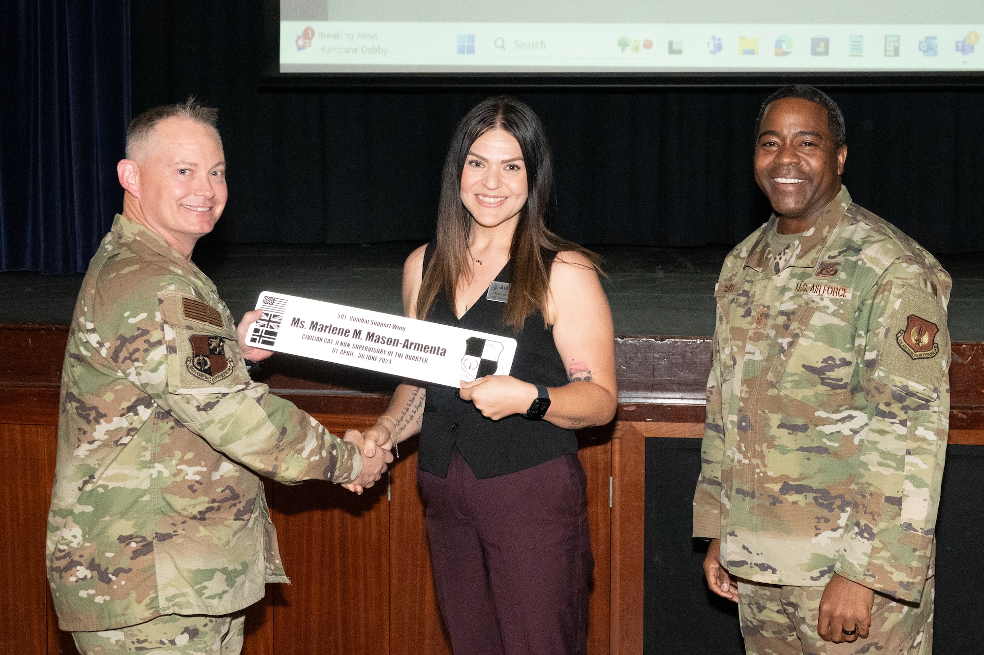 U.S. Air Force Col. D. Landon Phillips, 501st Combat Support Wing commander, left, and Chief Master Sgt. Terrance Boyd, 501st Combat Support Wing command chief, right, present Ms. Marlene M. Manson-Armenta, 422nd Air Base Squadron Numbered Air Force (NAF) contracting officer, with a civilian category II non-supervisory of the quarter award.