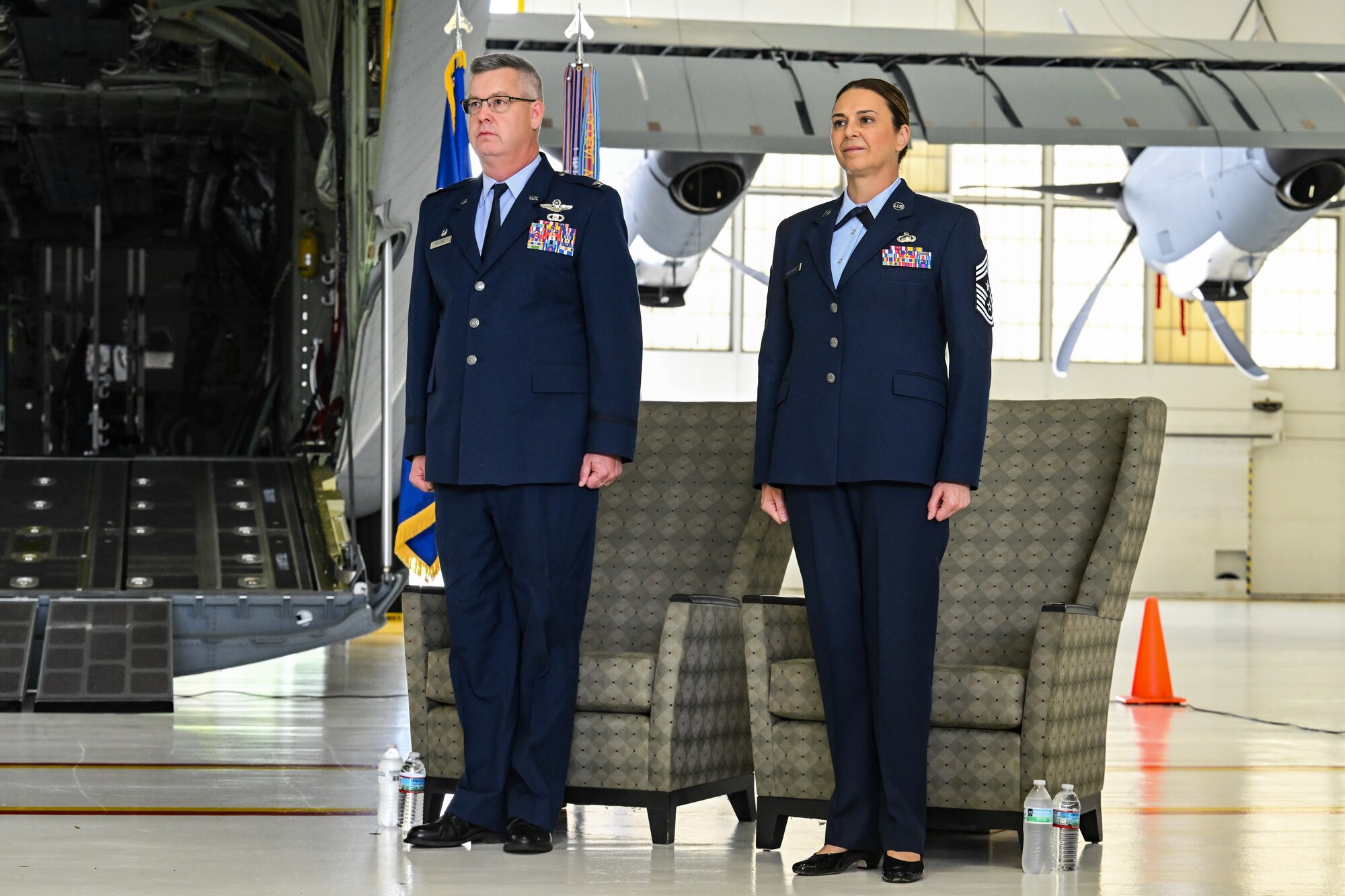Col. Michael Maloney, 910th Airlift Wing commander, and Chief Master Sgt. Jennifer McKendree, 910th AW command chief, stand at attention for the national anthem during McKendree's retirement ceremony at Youngstown Air Reserve Station, Ohio, Aug. 3, 2024.