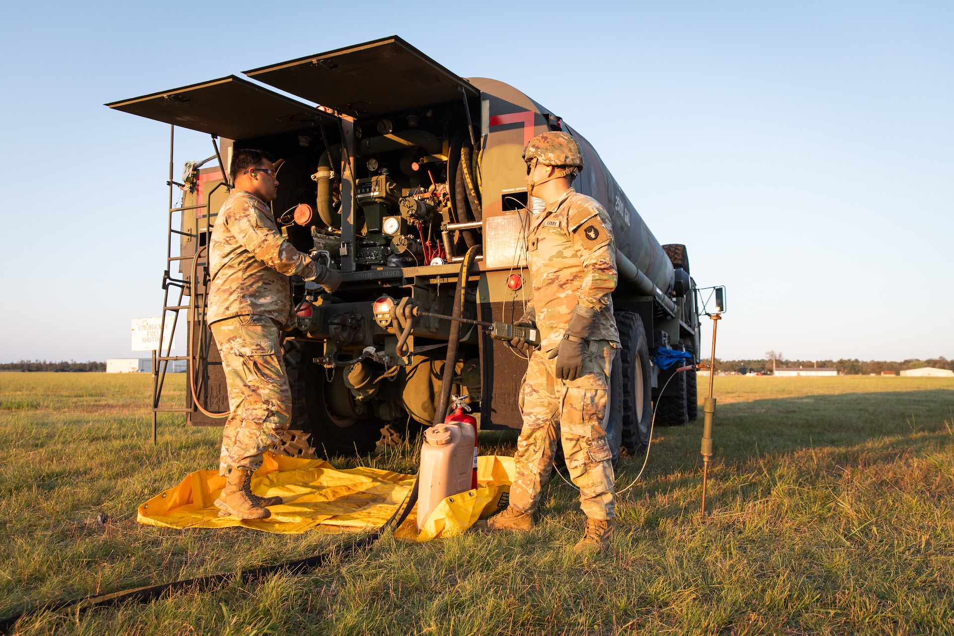 U.S. Army Spc. Andre Delgado (left) and Spc. Shawn Rodriguez (right) prepare the fuel truck during a UH-60 Blackhawk "hot fuel" on Camp Grayling Army Airfield in Grayling, Michigan on July 16, 2024. Delgado and Rodriguez are fuelers in Echo Company 2/147th Assault Helicopter Battalion, 63rd Theater Aviation Brigade,  who was conducting aerial gunnery during their annual training. (U.S. Army National Guard photo by Sgt. 1st Class Andrew Dickson)