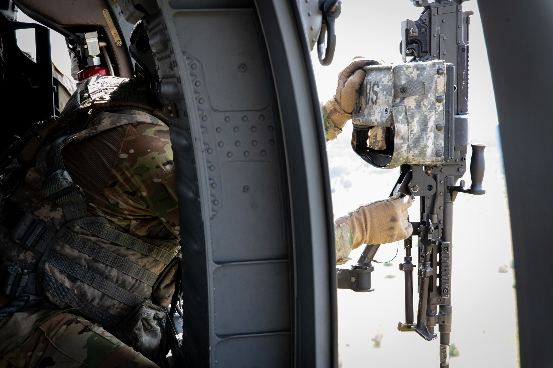 U.S. Army Sgt. Noah Perdue stabilizes his M240 machine gun in a UH-60 Blackhawk at Camp Grayling Army Airfield in Grayling, Michigan on July 16, 2024. Perdue is a Soldier in Bravo Company 2/147th Assault Helicopter Battalion, 63rd Theater Aviation Brigade,  who was conducting aerial gunnery during their annual training. (U.S. Army National Guard photo by Sgt. 1st Class Andrew Dickson)