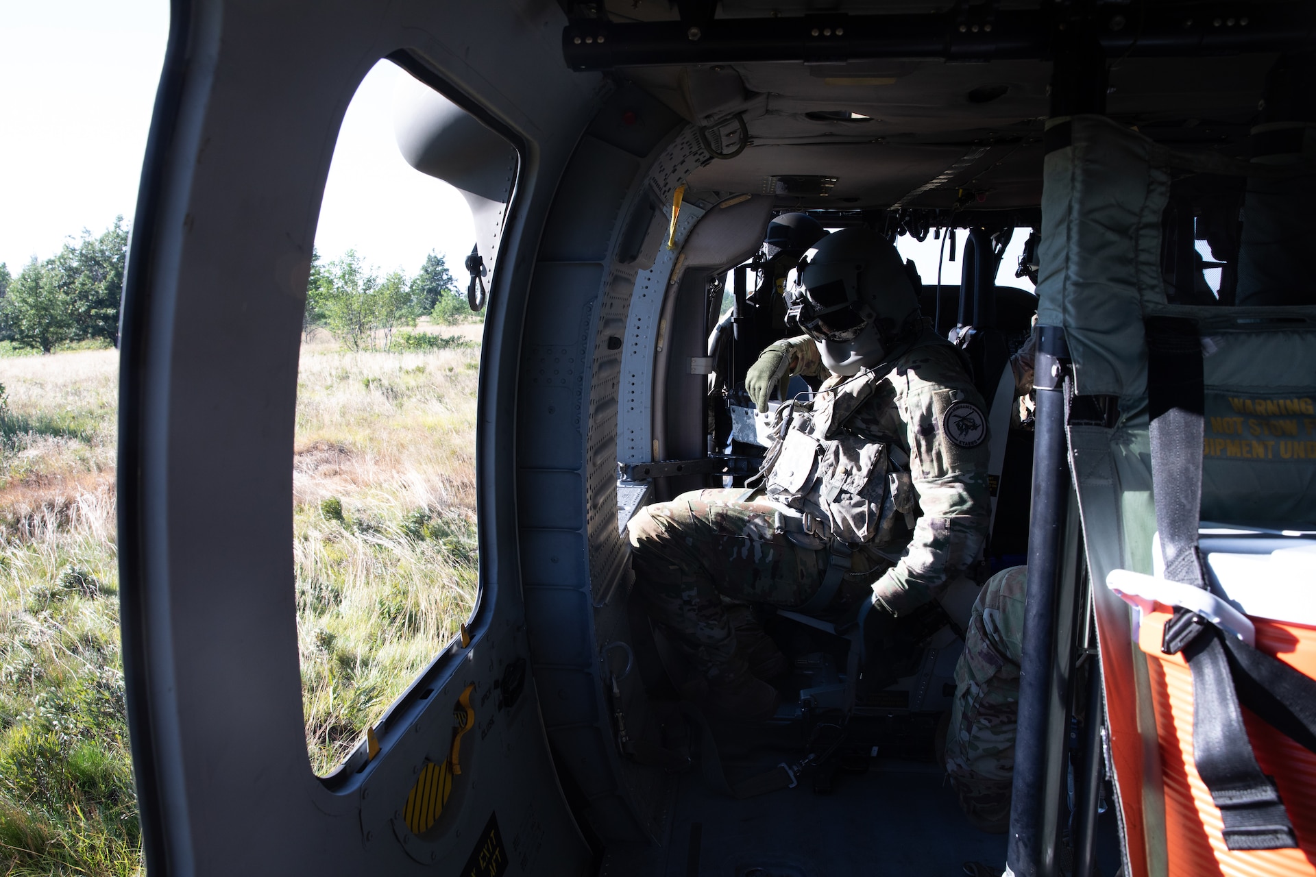 U.S. Army Spc. Austin Banks adjust his seat in a UH-60 Blackhawk helicopter before gunnery at Camp Grayling Army Airfield in Grayling, Michigan on July 16, 2024. Banks is a Soldier in Bravo Company 2/147th Assault Helicopter Battalion, 63rd Theater Aviation Brigade,  who was conducting aerial gunnery during their annual training. (U.S. Army National Guard photo by Sgt. 1st Class Andrew Dickson)