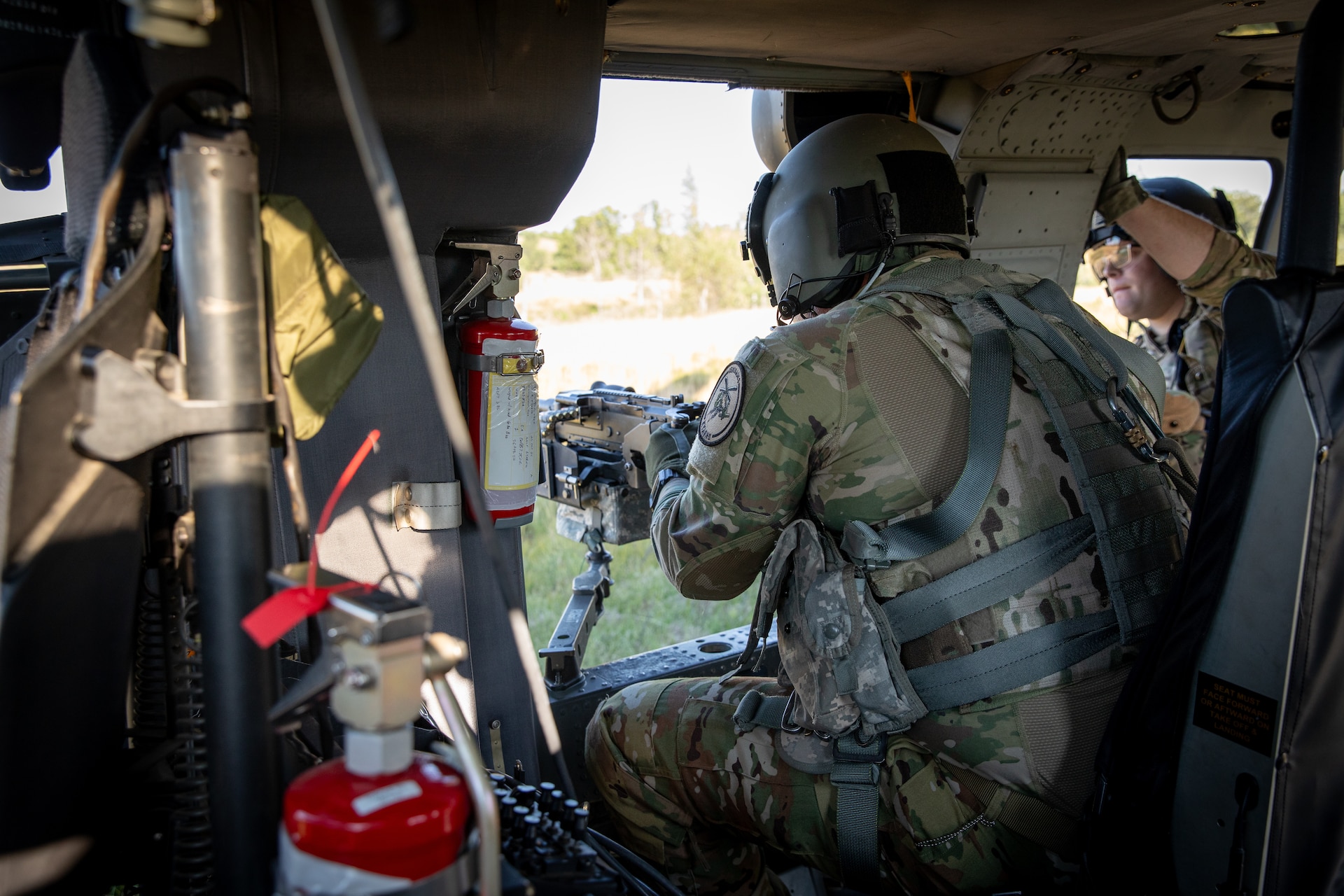 U.S. Army Spc. Austin Banks fires the M240 machine gun in a UH-60 Blackhawk at Camp Grayling Army Airfield in Grayling, Michigan on July 16, 2024. Banks is a Soldier in Bravo Company 2/147th Assault Helicopter Battalion, 63rd Theater Aviation Brigade,  who was conducting aerial gunnery during their annual training. (U.S. Army National Guard photo by Sgt. 1st Class Andrew Dickson)