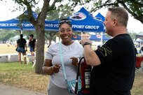 Two people talking while at an outdoor event on base.