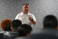 Male speaking to a room of servicemembers.