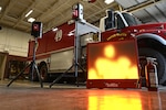 Digital screen on floor next to a fire truck