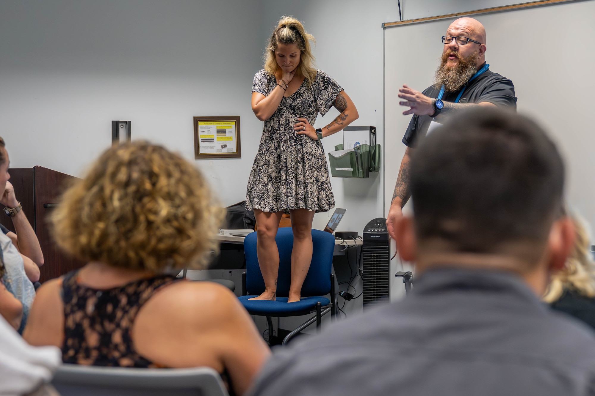 woman stands on chair during ASIST class