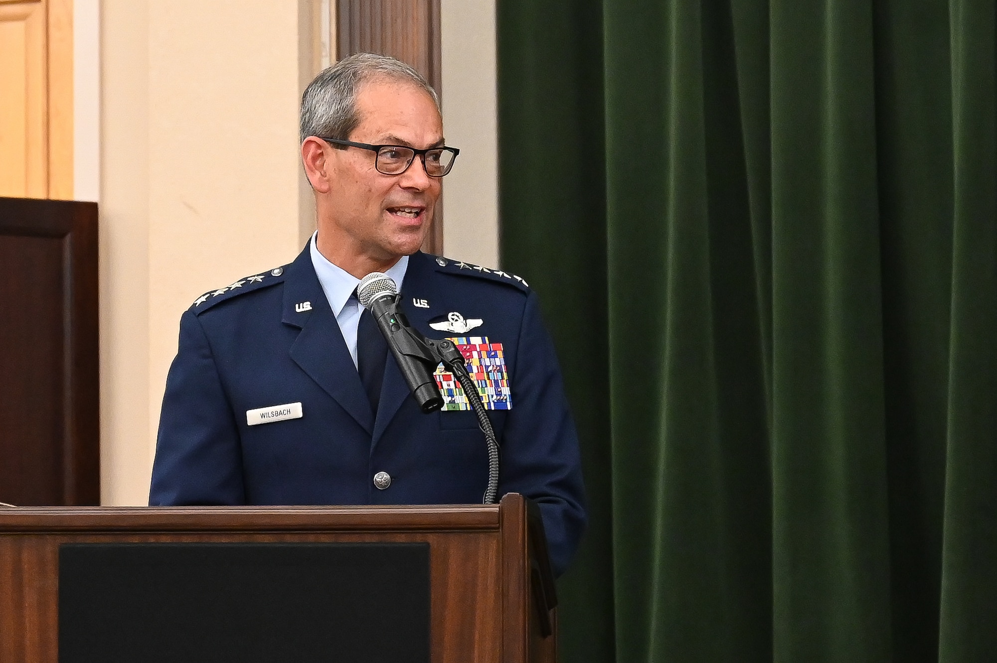 Air Combat Commander speaks at podium.
