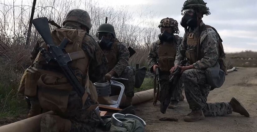 Marines work together in a field.