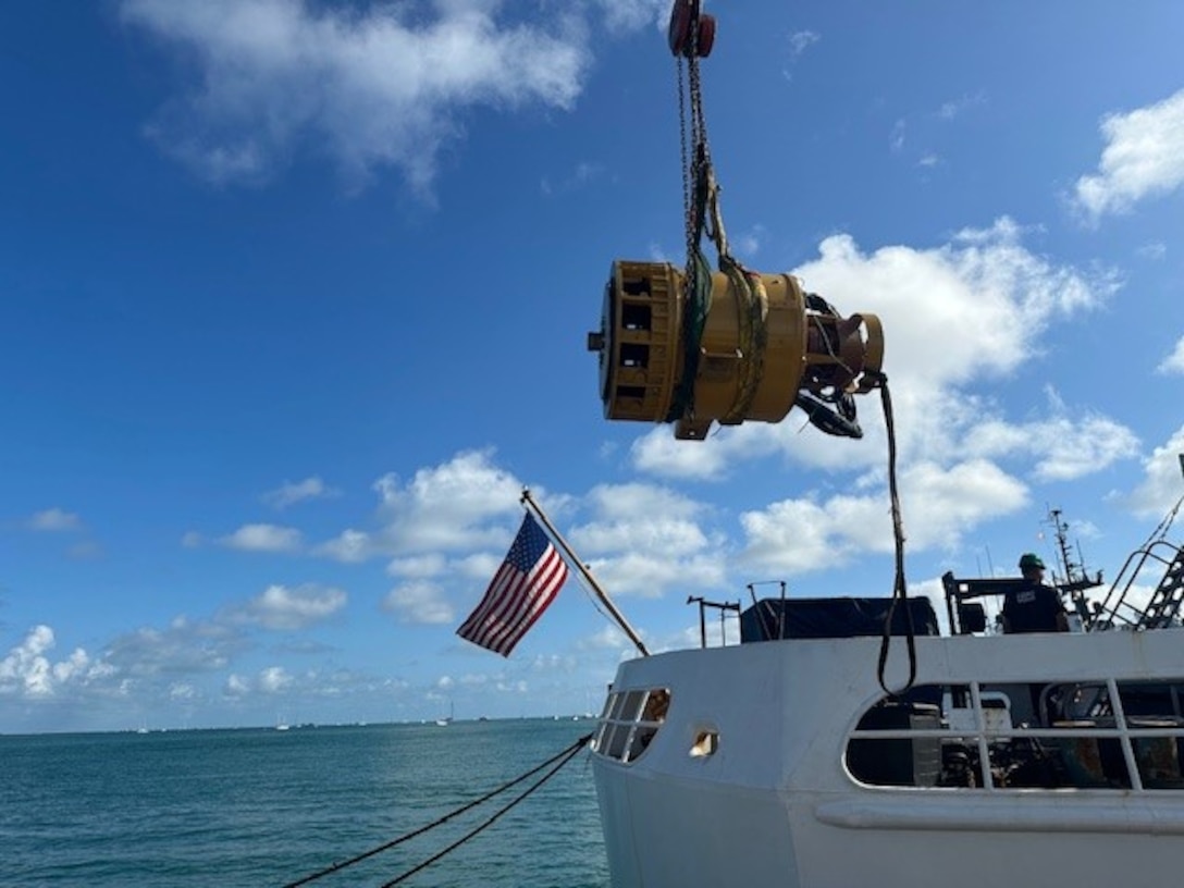 The crew of the Coast Guard Cutter Venturous lower a replacement Emergency Diesel Generator using a crane and pulley system on July 1, 2024, in Key West, Florida. The ship’s engineers worked to make the critical replacement in just 96 hours. (U.S. Coast Guard photo by Lt. Anthony Medlar)