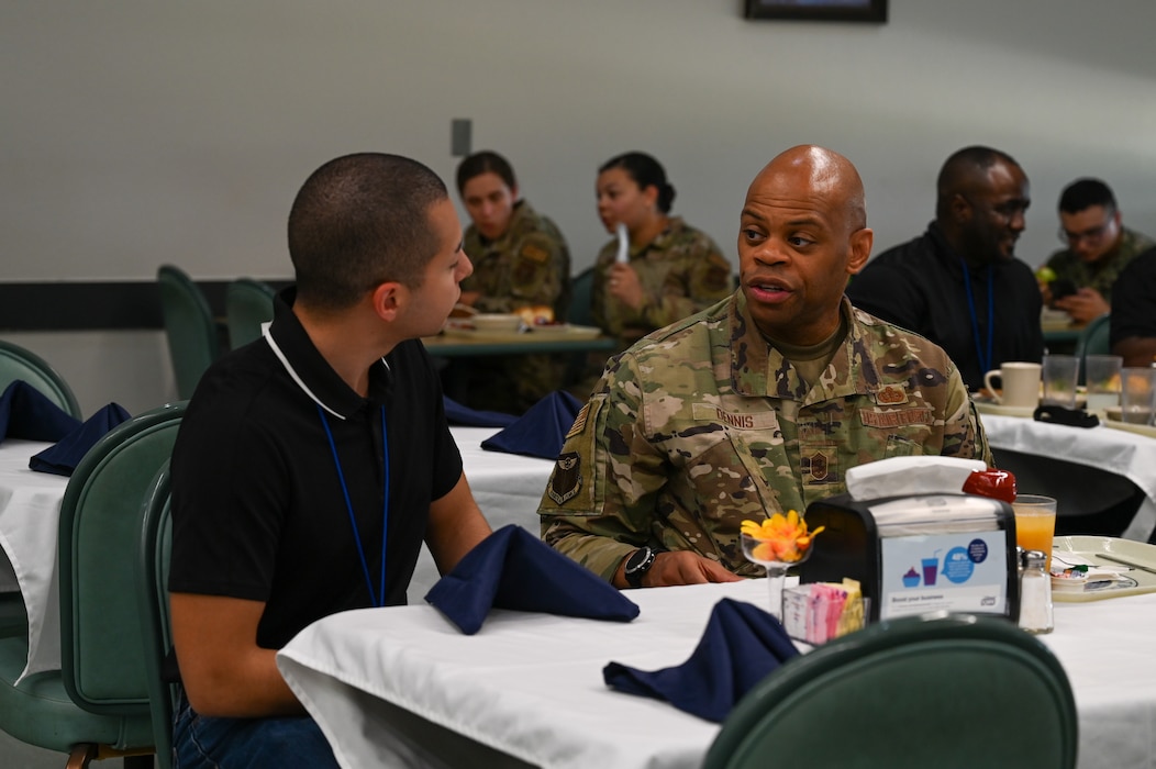 Chief Master Sgt. Travon Dennis, 4th Air Force command chief, eats and visits with Development and Training Flight Airmen at the Mesquite Dining Inn at Joint Base San Antonio-Lackland, Texas, Aug. 4, 2024.