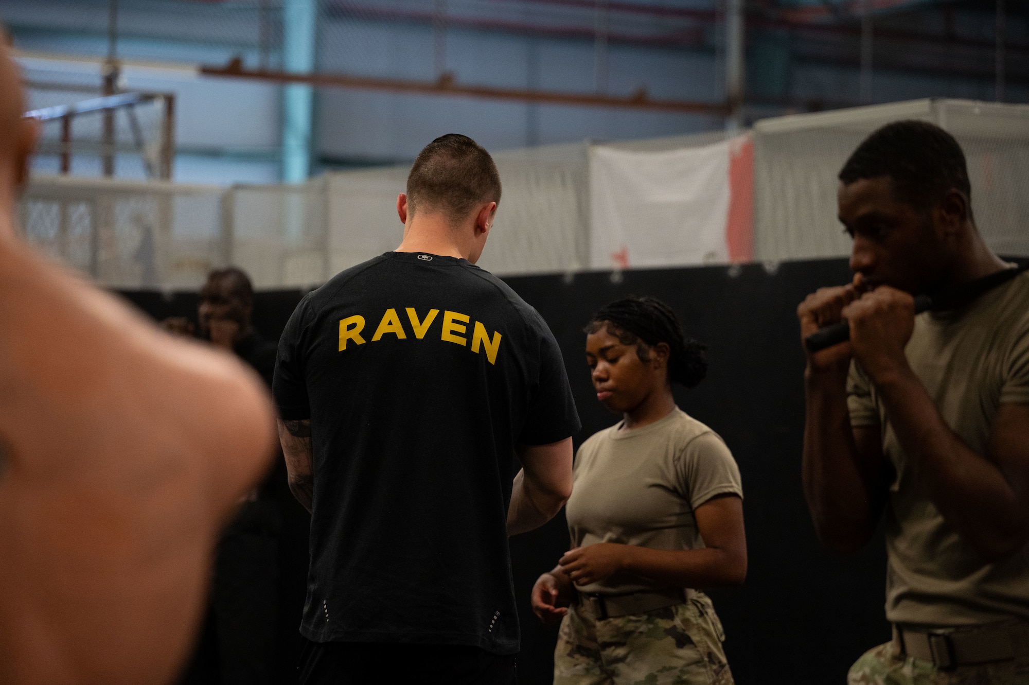 U.S. Air Force Staff Sgt. Daniel Reimer, 436th Security Forces Squadron Phoenix Ravens team leader, assists an Airman during non-lethal baton training at the Ravens training building at Dover Air Force Base, Aug. 6, 2024. The baton is one of the basic skills that Airmen in Security Forces learn during their training. (U.S. Air Force photo by Airman Liberty Matthews)