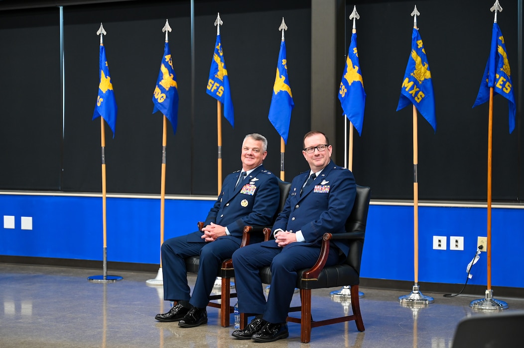 Maj. Gen. D. Scott Durham, 4th Air Force commander, and Col.  Douglas C. Jeffrey, IV, 433rd Airlift Wing commander, sit next to one another during the 433rd AW assumption of command ceremony at Joint Base San Antonio-Lackland, Texas, Aug. 4, 2024.