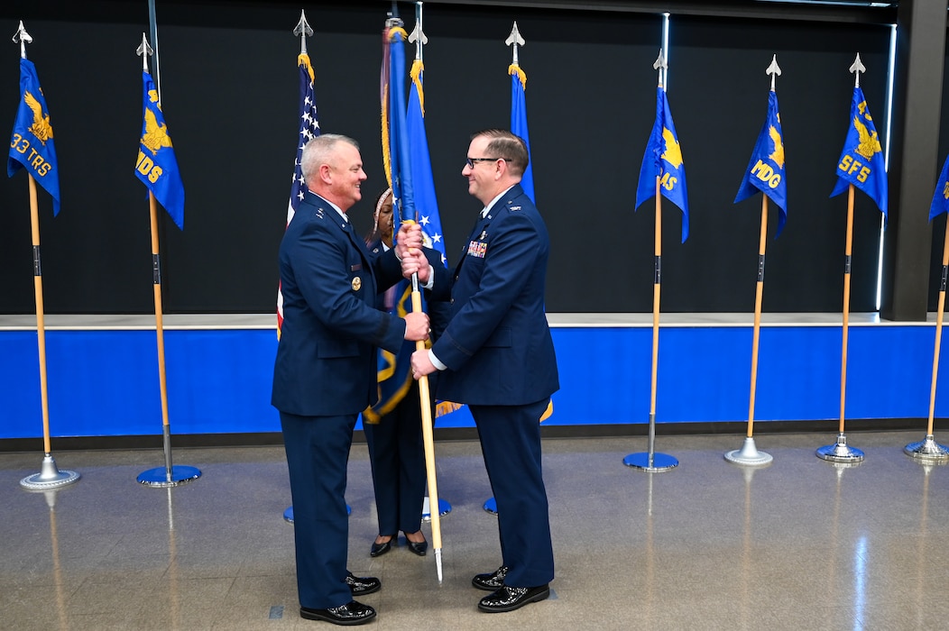 Maj. Gen. D. Scott Durham, 4th Air Force commander, presents the 433rd Airlift Wing guidon to Col. Douglas C. Jeffrey, IV, 433rd AW commander, during the 433rd AW assumption of command ceremony at Joint Base San Antonio-Lackland, Texas, Aug. 4, 2024.