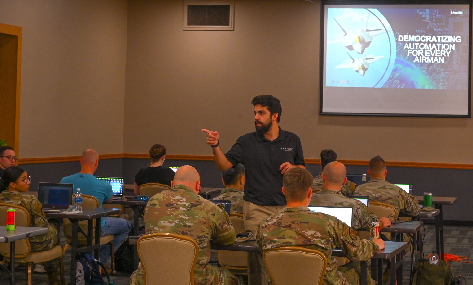 Kamlen Joshi, Invoke robotic processes automation (RPA) instructor, speaks to students about automating processes during the RPA course at Minot Air Force Base, North Dakota, August 6, 2024. The purpose of the roadshow was to have students think critically about what improvements can be made in their everyday processes using RPA.