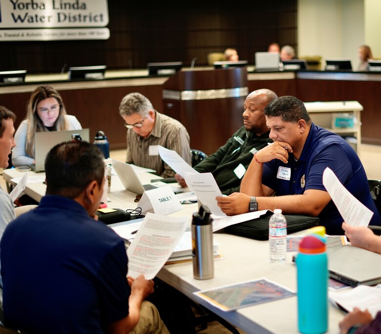 Small group members analyze the details of an emergency scenario during the Carbon Canyon Dam tabletop exercise July 31, 2024, at the Yorba Linda Water District in Placentia, California.