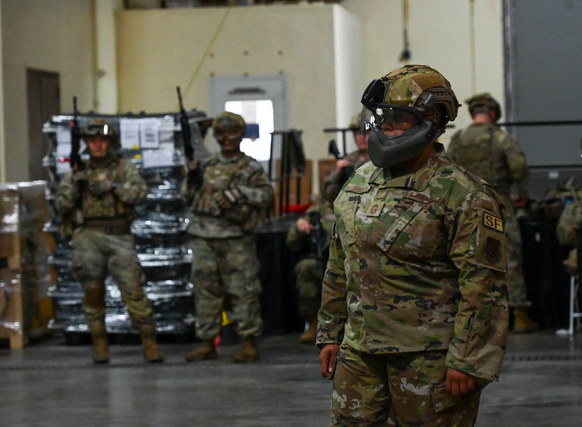 D.C. Air National Guard Chief Master Sgt. Yolanda Spikes observes as Security Forces members navigate building entry and room clearing procedures in a modular inflatable shoot house.