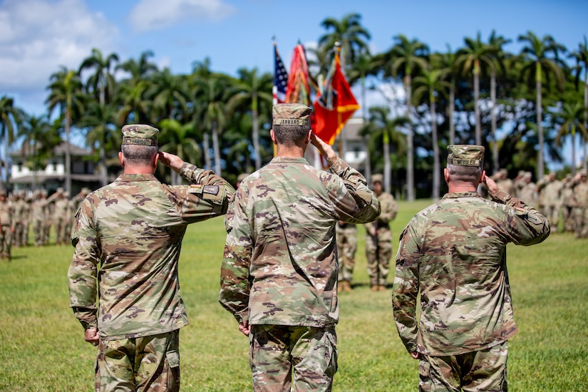 Brig. Gen Ray Phariss, Lt. Gen. James B. Jarrard and Brig. Gen. Kevin Meisler salute the flag during the playing of the national anthem at historic Palm Circle in Fort Shafter on July 19, 2024.