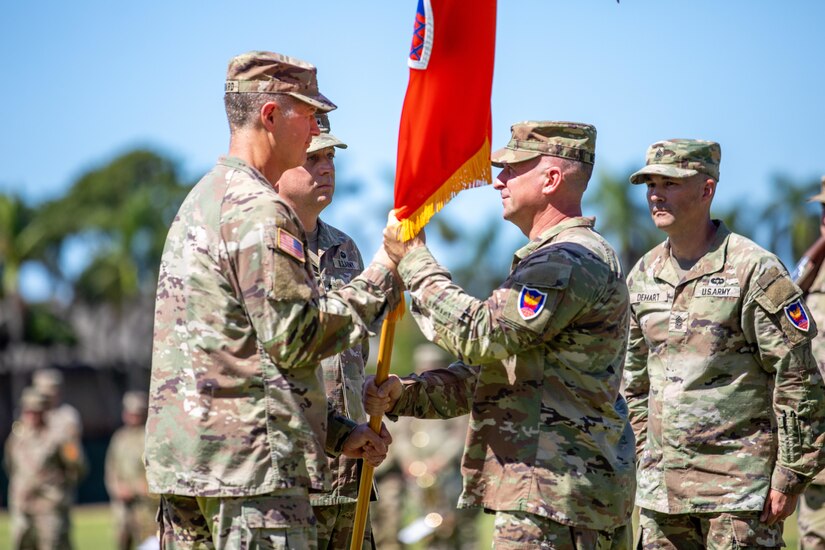 Brig. Gen. Kevin Meisler passes to colors to Lt. Gen. James B. Jarrard during the 311th Signal Command (Theater) change of command ceremony at historic Palm Circle in Fort Shafter on July 19, 2024.