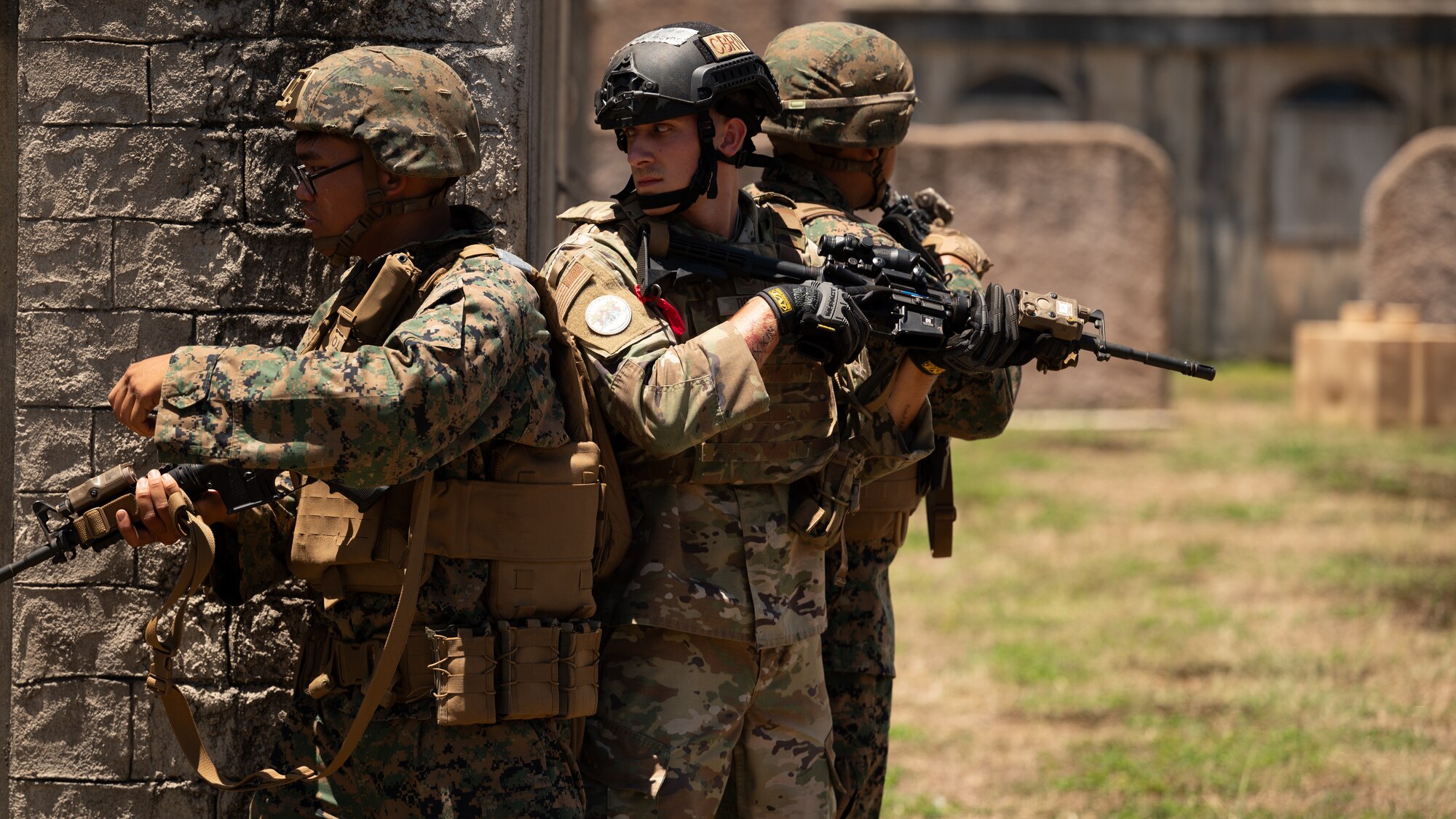 Members of the U.S. Marine Corps and U.S. Air Force Airman 1st Class William Dobyns, 647th Civil Engineer Squadron emergency management journeyman, rehearse room clearing procedures during exercise Toxic Swell on Marine Corps Training Area Bellows, Hawaii, Aug. 6, 2024. The 60 military personnel practiced Agile Combat Employment concepts, including Chemical, Biological, Radioactive, Nuclear, safety procedures, and close-quarters combat training. (U.S. Air Force photo by Senior Airman Mark Sulaica)