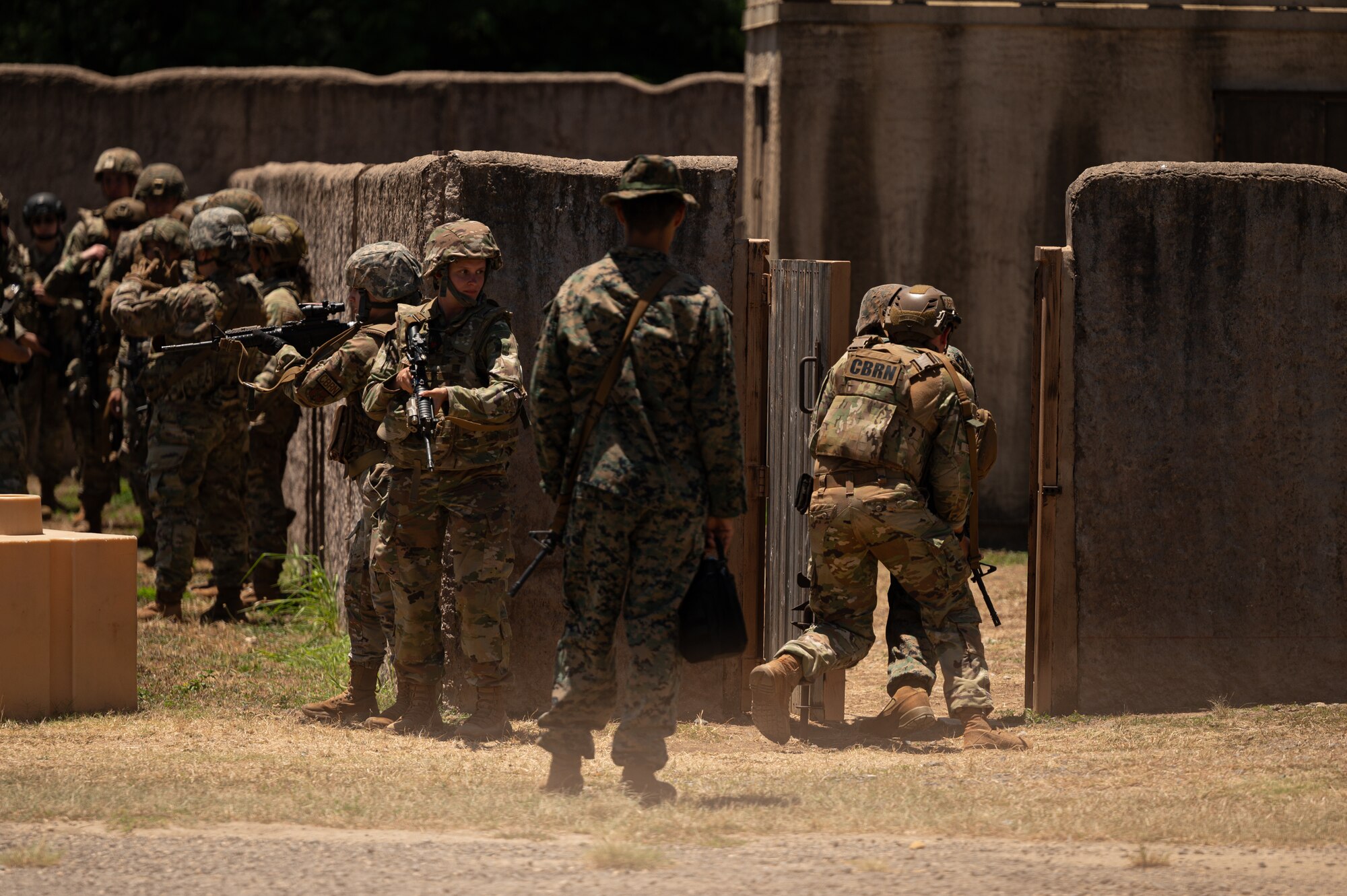 Airmen across the Pacific Air Forces, Reserves, and Air National Guard and U.S. Marines from Marine Corps Base Hawaii, train together on close-quarter combat during exercise Toxic Swell on Marine Corps Training Area Bellows, Hawaii, Aug. 6, 2024. The 60 military personnel practiced Agile Combat Employment concepts, including Chemical, Biological, Radioactive, Nuclear, safety procedures, and close-quarters combat training. (U.S. Air Force photo by Senior Airman Mark Sulaica)