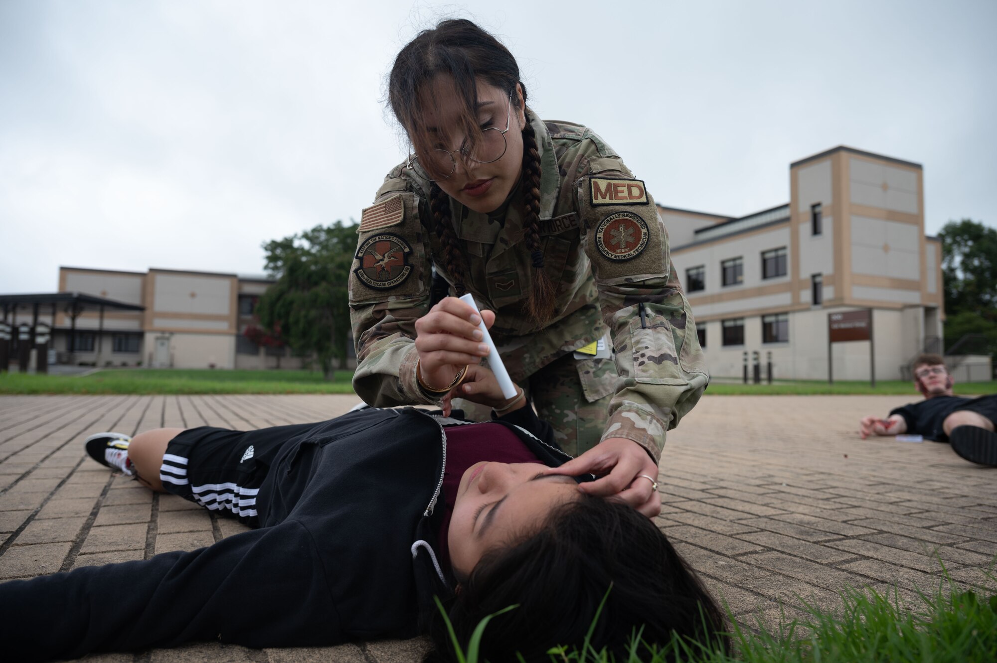 U.S. Air Force Airman 1st Class Maria Mirkhan, 436th Health Care Operations Squadron ambulance response team member, performs the PERRLA eye test on a patient during the Ready Eagle II exercise at Dover Air Force Base, Delaware, Aug. 8, 2024. The exercise was used to test Medical Contingency Response Plan Readiness and the current response capabilities for mass casualty care. (U.S. Air Force photo by Senior Airman Dieondiere Jefferies)