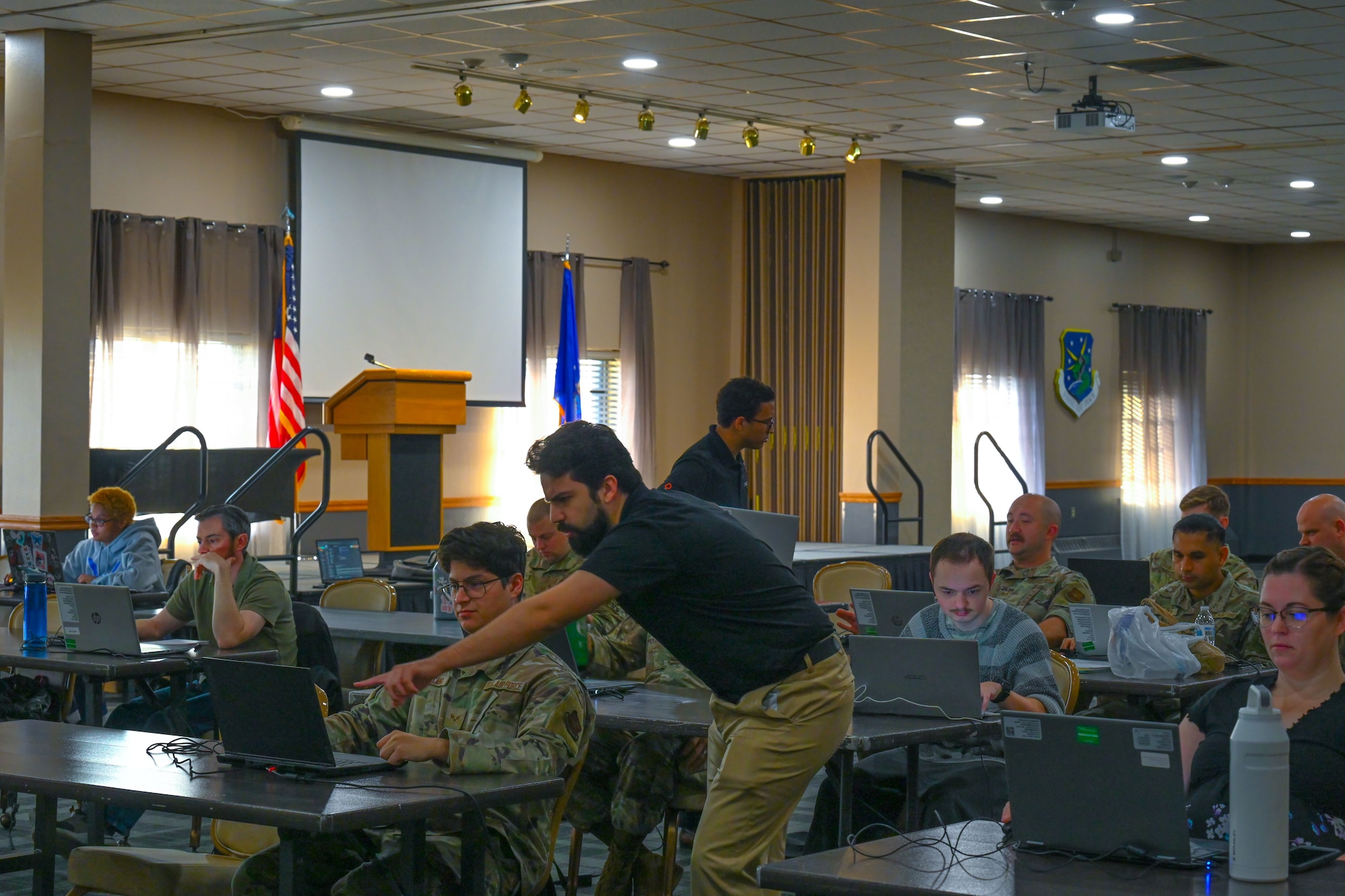 Kamlen Joshi and Marcellous Curtis, Invoke robotic processes automation (RPA) instructors, show students how to build an automation during the RPA course at Minot Air Force Base, North Dakota, August 6, 2024. The RPA instructors helped students create automations intended to increase productivity and decrease time spent working.