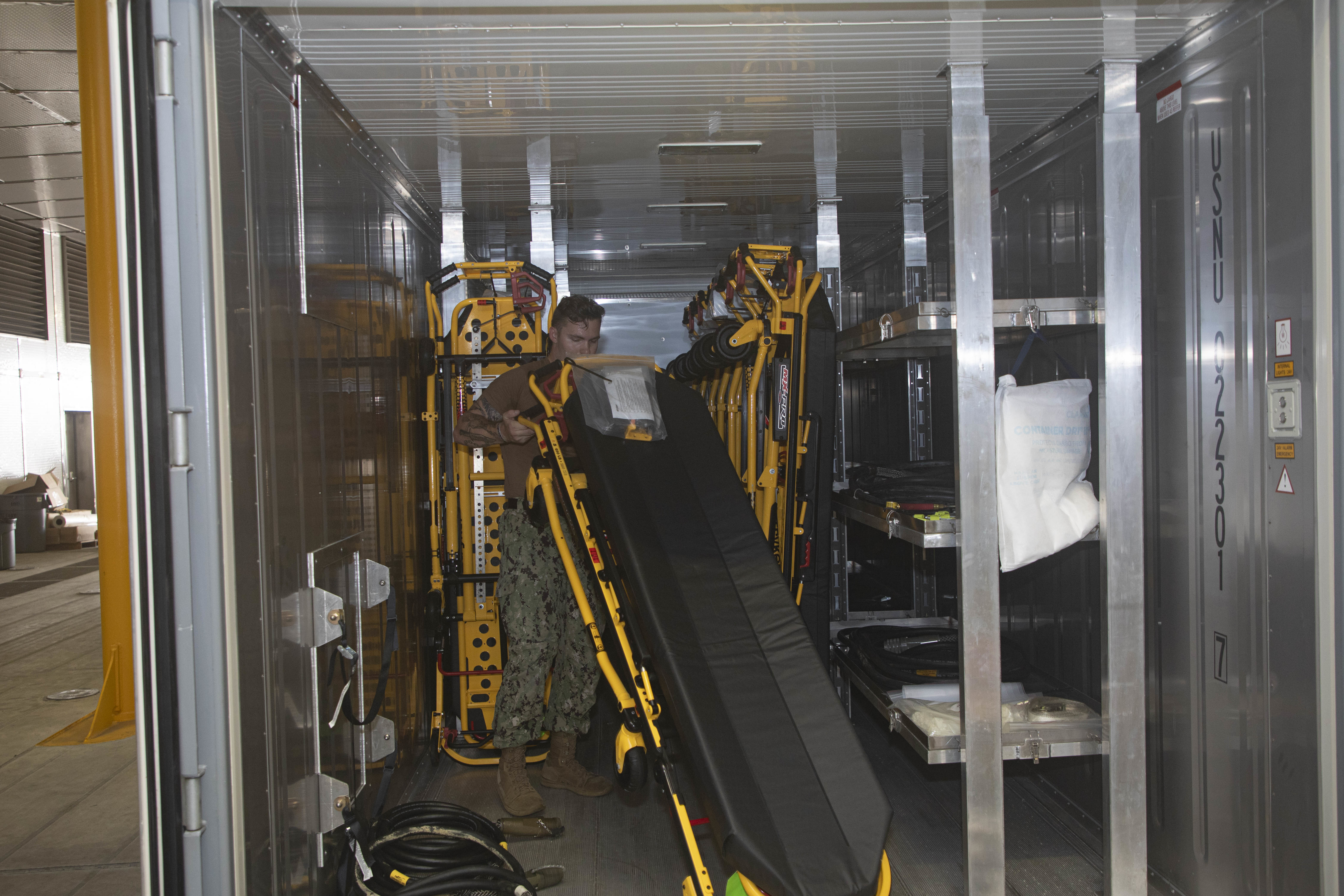 240722-N-KC192-1081 JOINT EXPEDITIONARY BASE LITTLE CREEK-FORT STORY, Va. (July 22, 2024) Hospital Corpsman 3rd Class Jacob ColeAllen, assigned to Navy Medicine Readiness and Training Command (NMRTC) Jacksonville, stores a gurney for pack up onboard the transport ship USNS Cody (T-EPF 14), July 22, 2024. The U.S. Navy is embarking the first Expeditionary Medical Unit (EMU), a cutting-edge medical support system with support personnel from EMU-1, designed to provide Role 2 level healthcare services both afloat and ashore.  (U.S. Navy photo by Mass Communication Specialist 2nd Class Levi Decker)