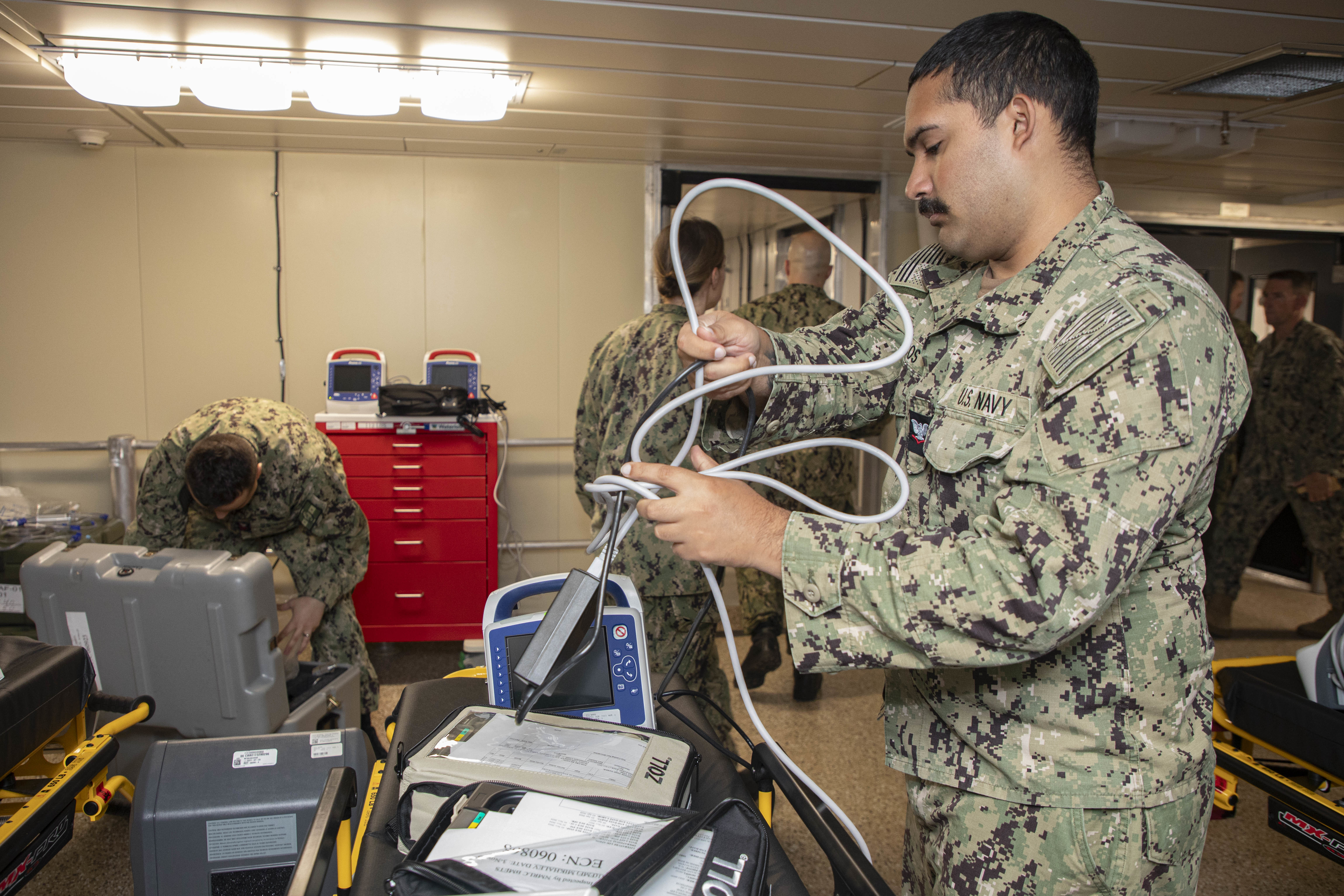 240722-N-KC192-1027 JOINT EXPEDITIONARY BASE LITTLE CREEK-FORT STORY, Va. (July 22, 2024) Hospital Corpsman 3rd Class Ronald Ducos, assigned to Navy Medicine Readiness and Training Command (NMRTC) Jacksonville, disassembles equipment for pack up onboard the transport ship USNS Cody (T-EPF 14), July 22, 2024. The U.S. Navy is embarking the first Expeditionary Medical Unit (EMU), a cutting-edge medical support system with support personnel from EMU-1, designed to provide Role 2 level healthcare services both afloat and ashore.  (U.S. Navy photo by Mass Communication Specialist 2nd Class Levi Decker)
