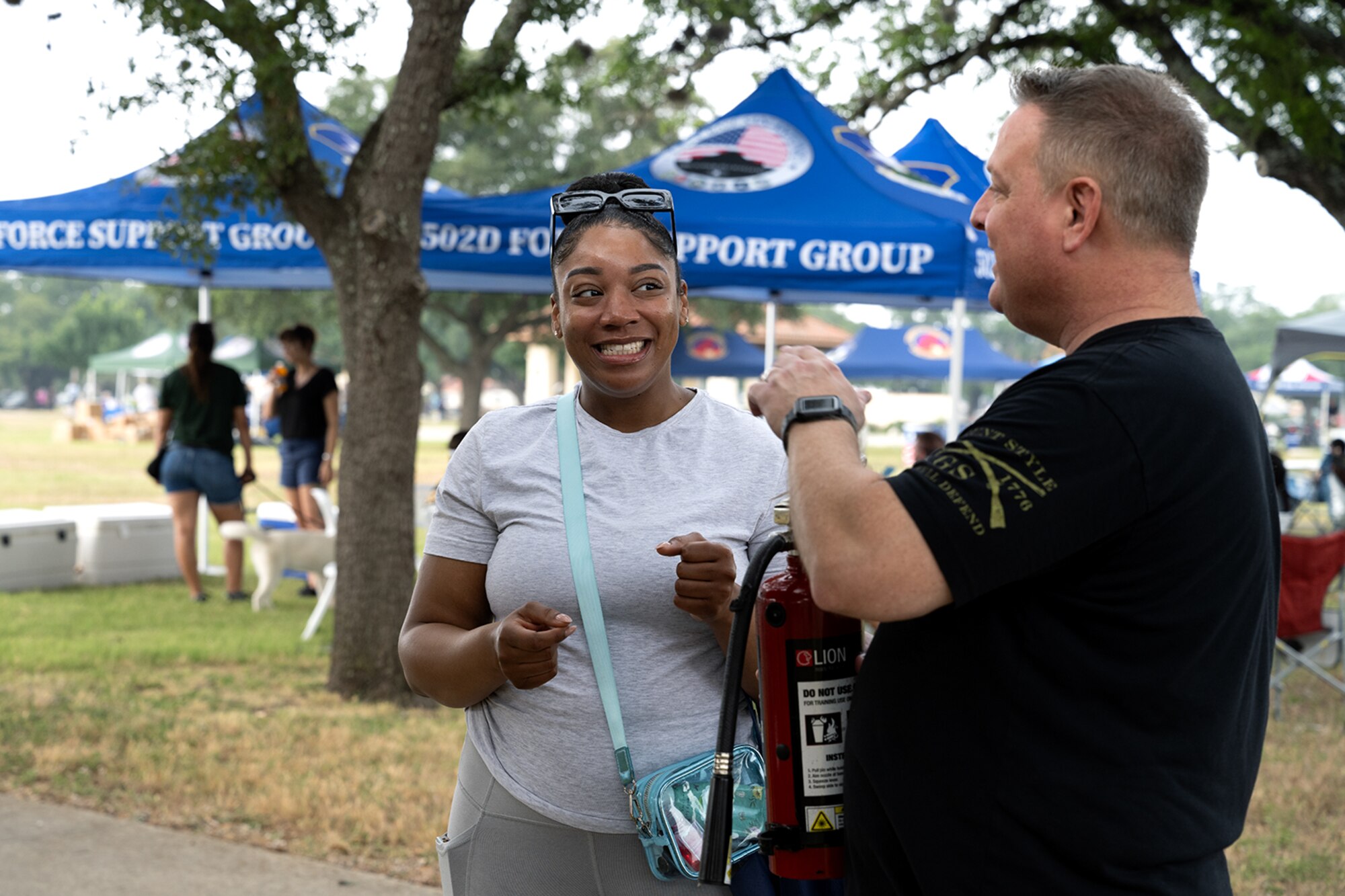 Two people talking while at an outdoor event on base.