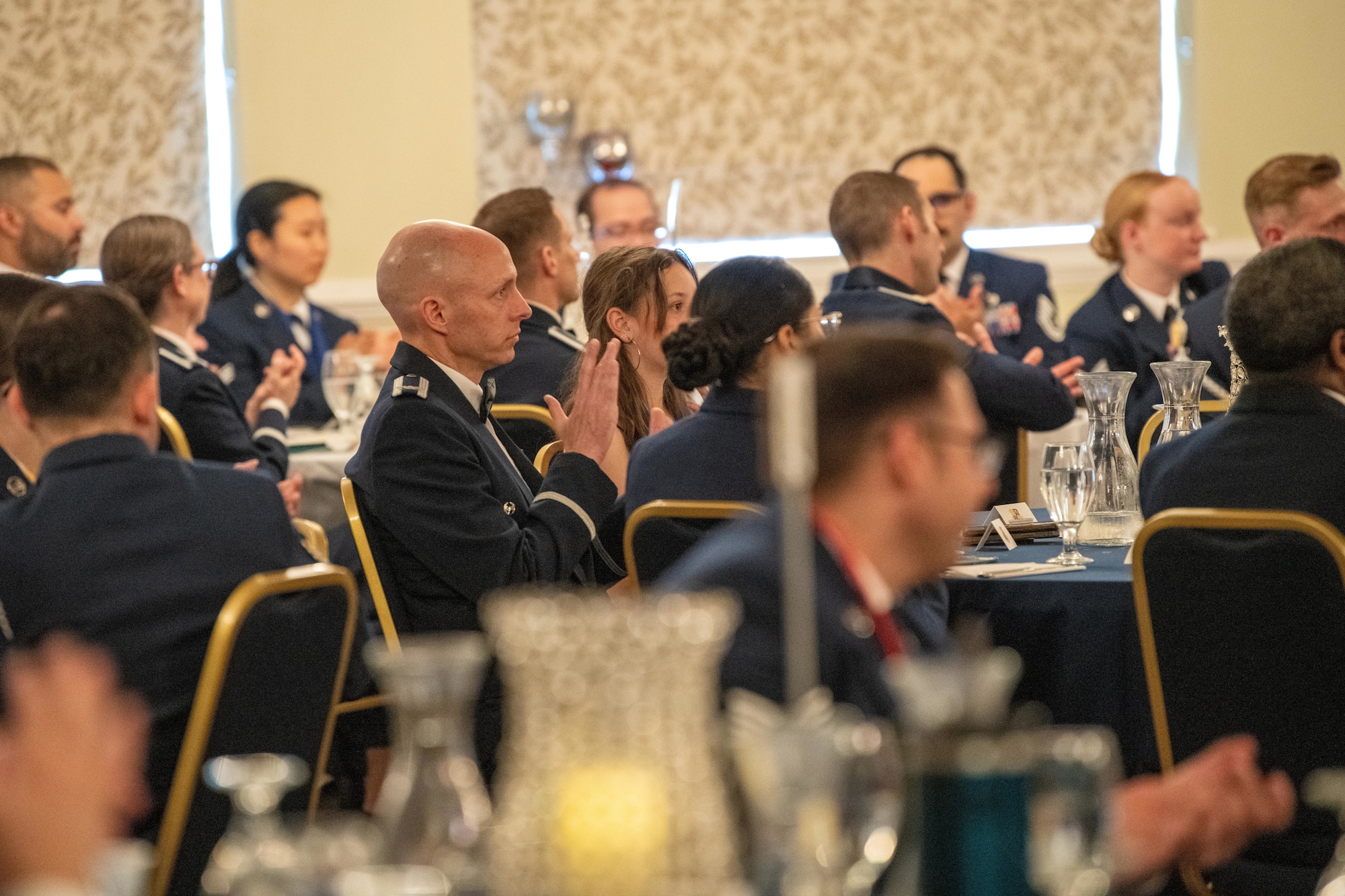 Attendees applaud during an Airman Leadership School graduation ceremony
