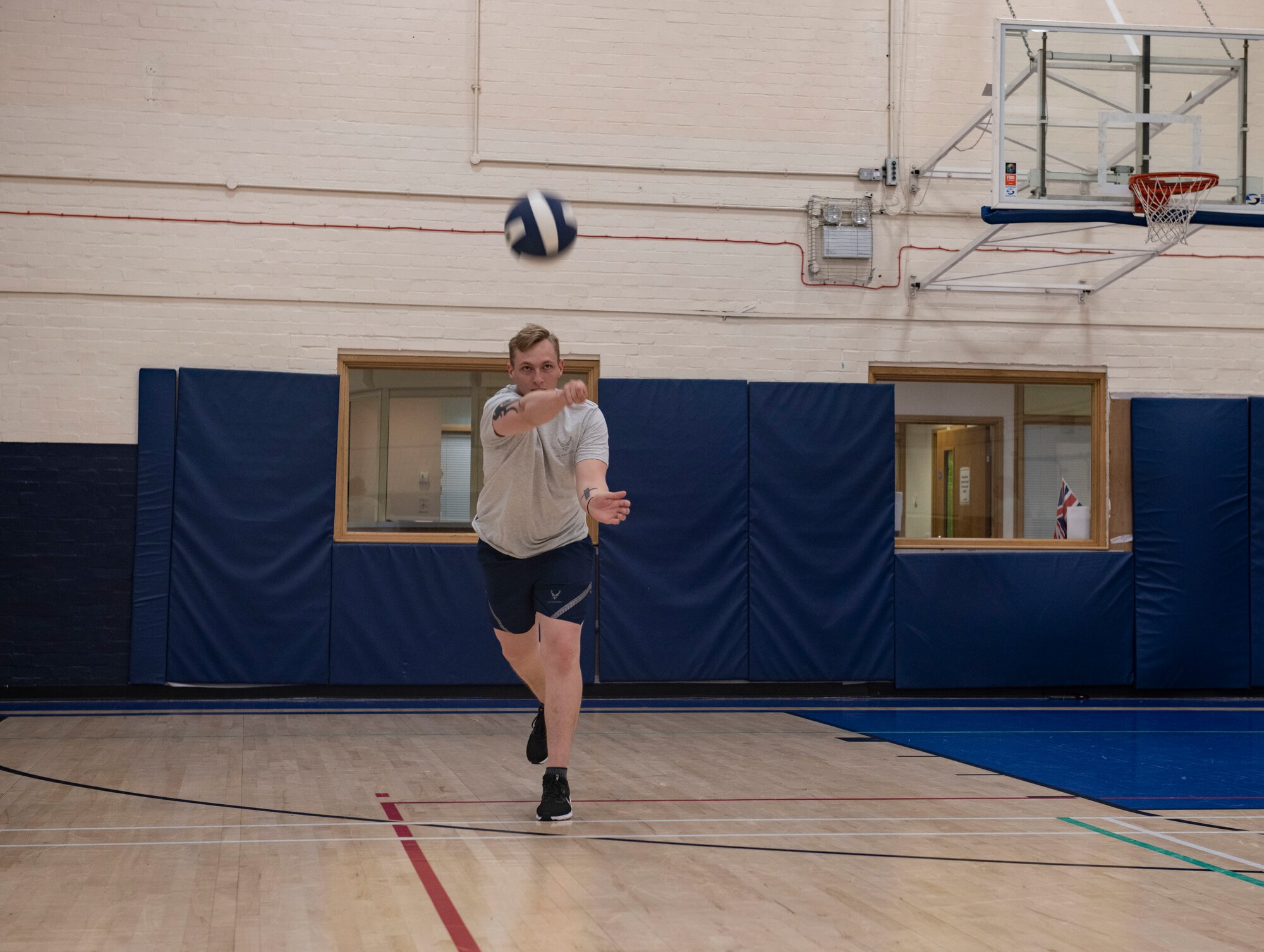 A students serves a volleyball
