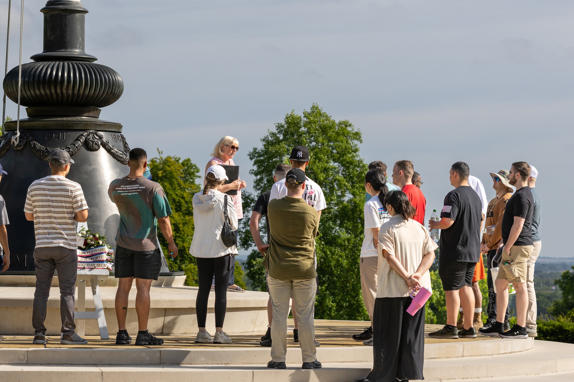 Airman Leadership School students listen to a history brief before a community service project
