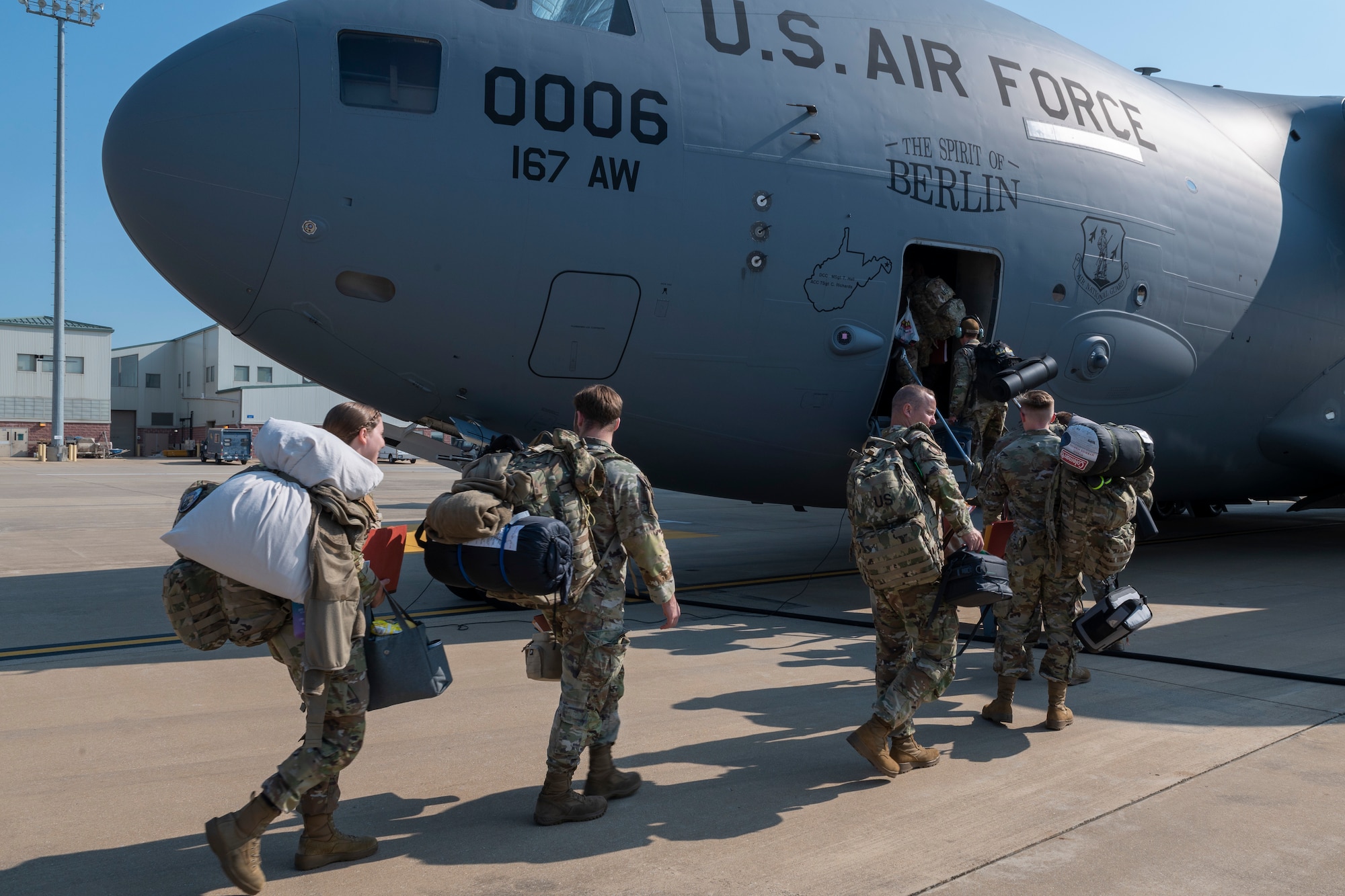 People in uniform enter a military aircraft