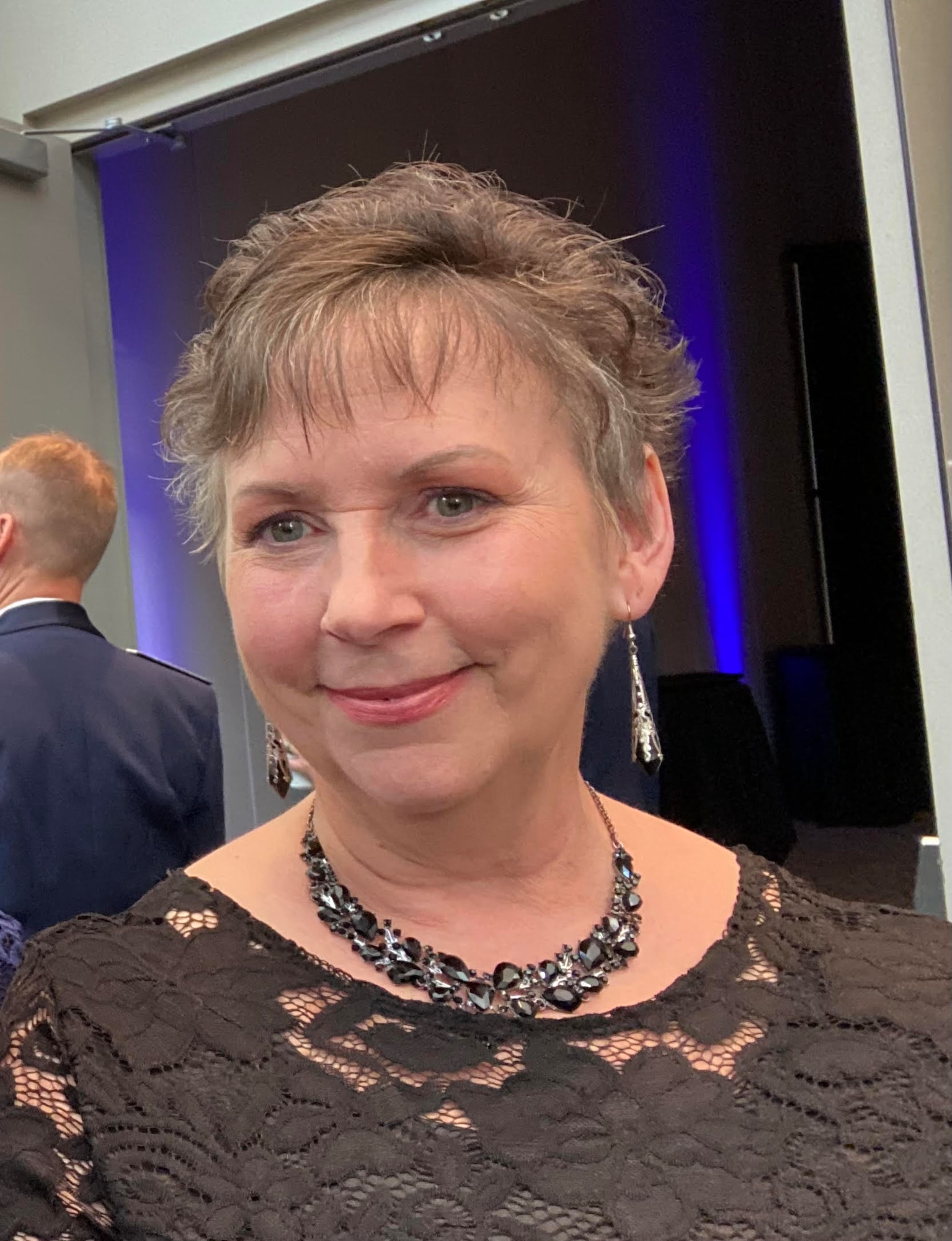 Beth Williams, Director of Psychological Services for the 439th Airlift Wing, poses for a photo.  She is waring a brown dress, with a necklace and earrings.