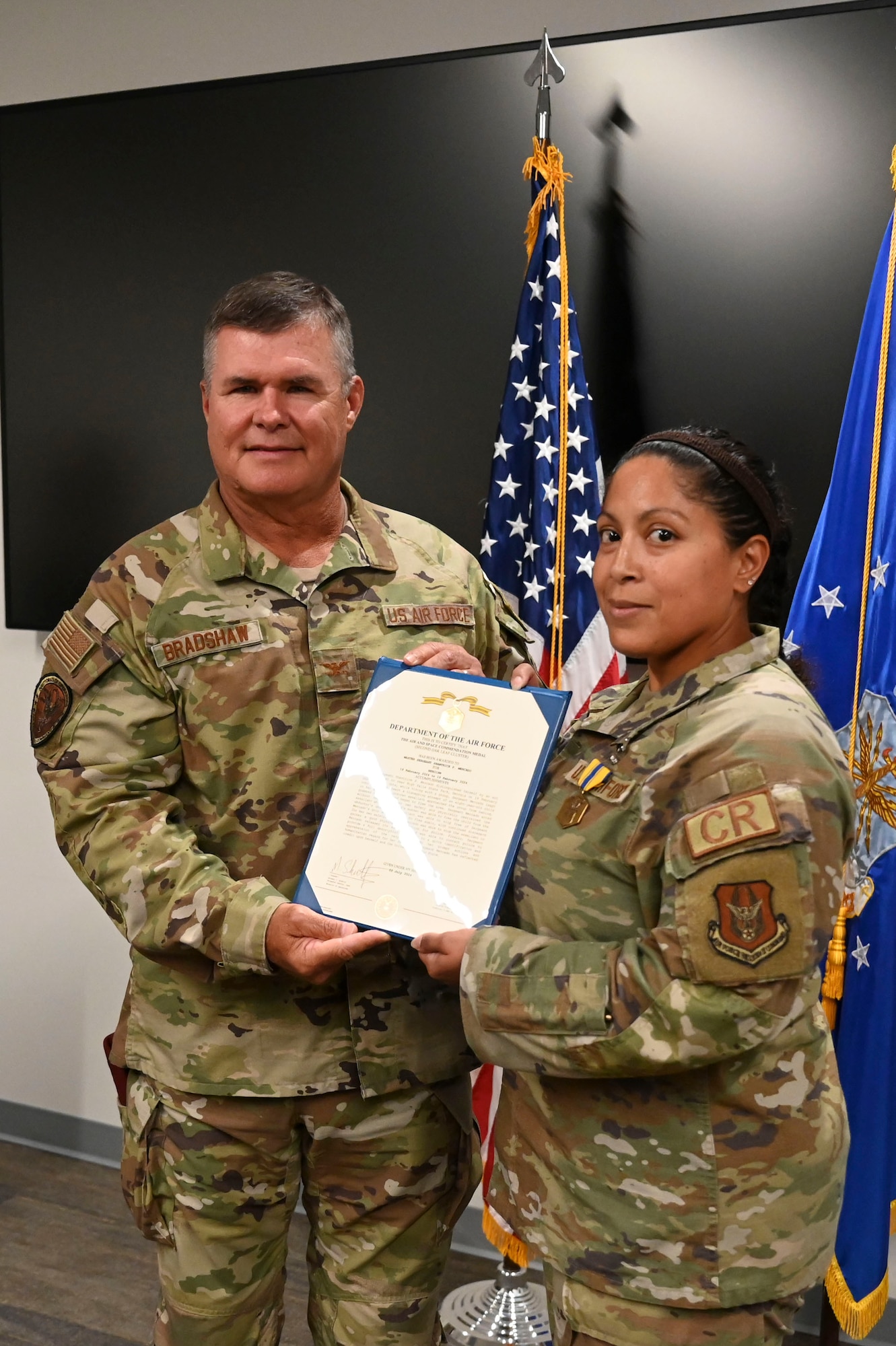 Man and woman in military uniform pose for a photo.