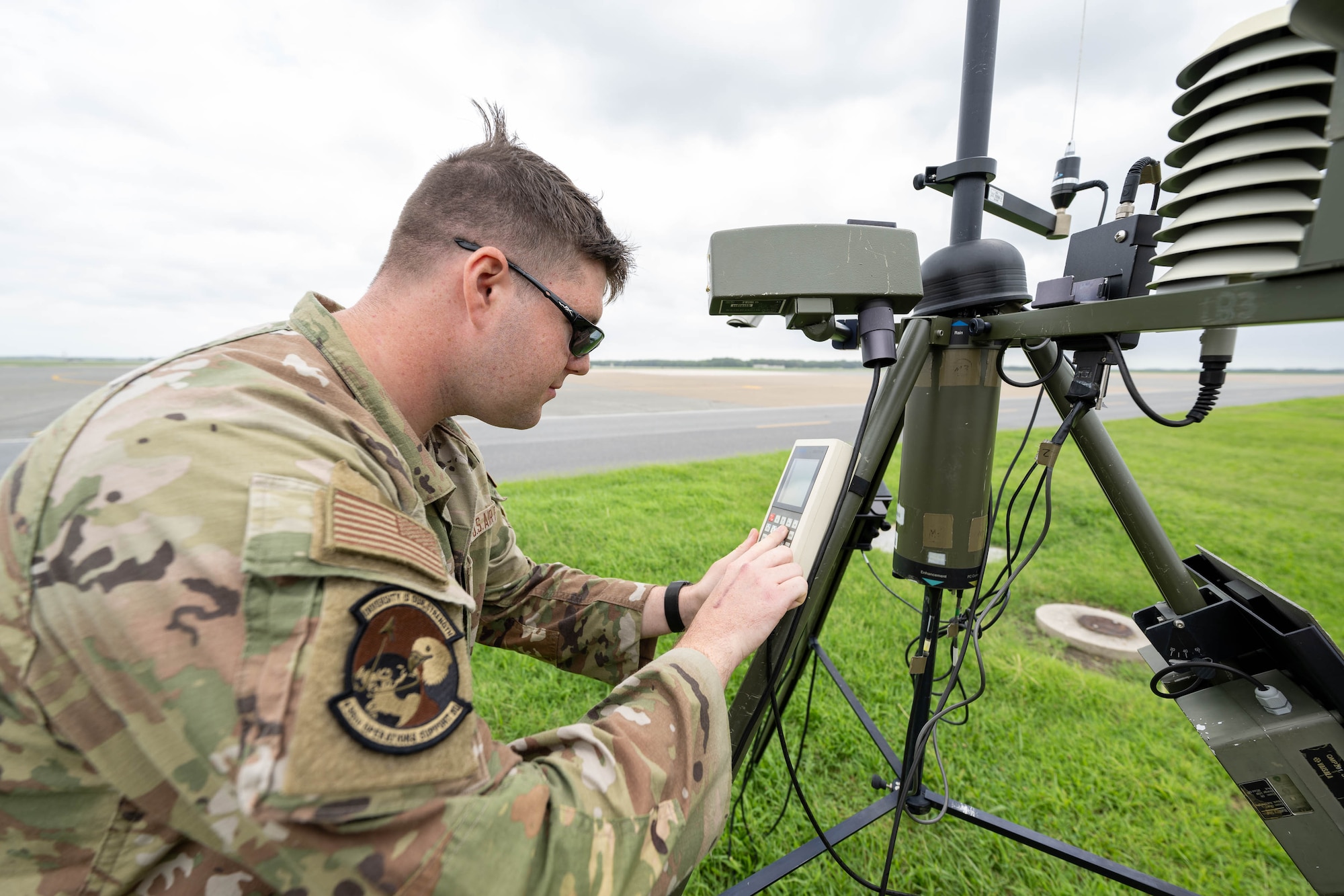 U.S. Air Force Airman 1st Class Alexander Johnson, 436th Operations Support Squadron radar airfield and weather systems apprentice, checks diagnostics on a tactical meteorological observing system at Dover Air Force Base, Delaware, Aug. 9, 2024. The instrument is used to detect wind direction, temperature, relative humidity, lightning, rain conditions, cloud depth and visibility to help provide weather patterns. (U.S. Air Force photo by Mauricio Campino)