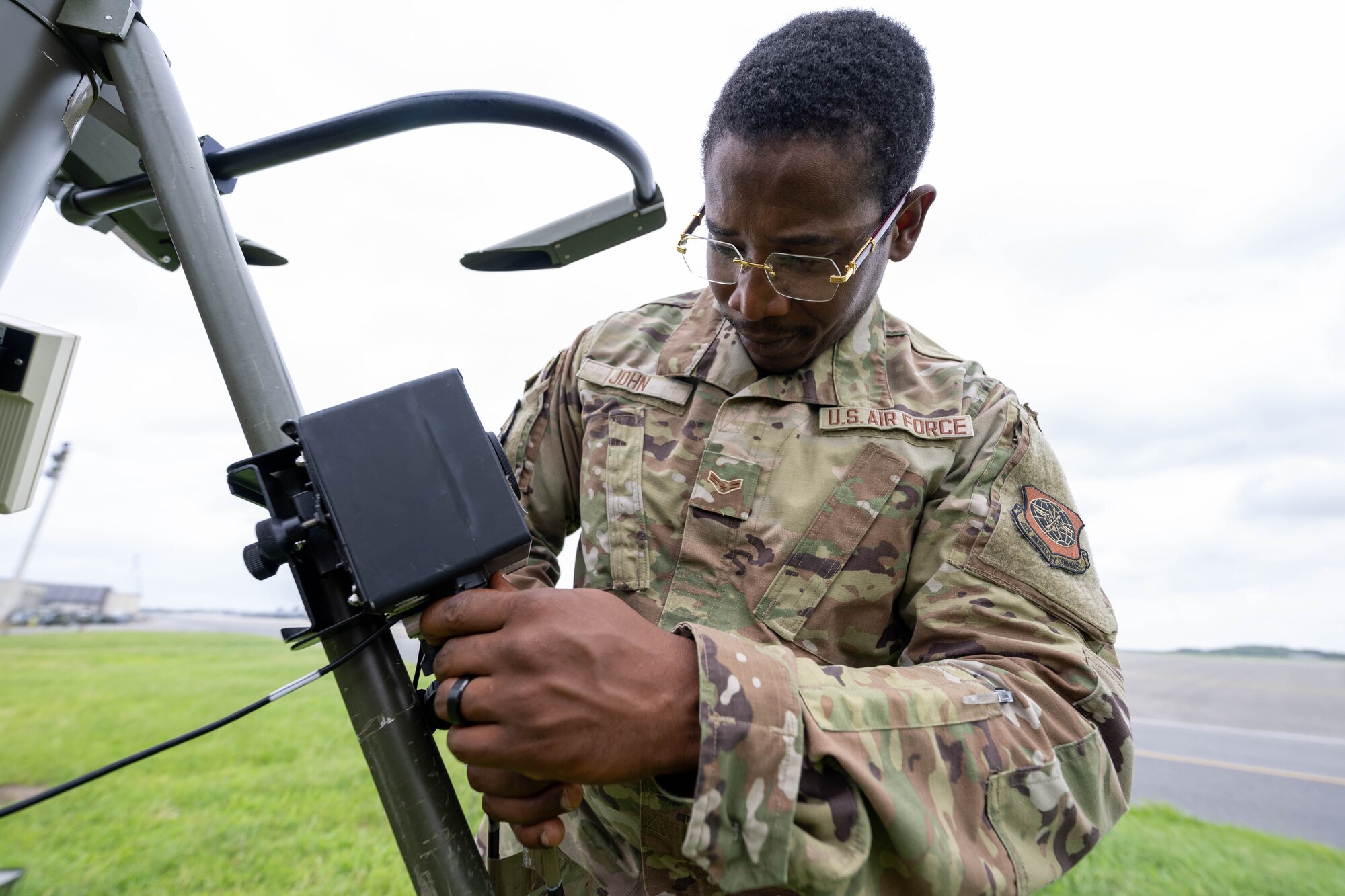 U.S. Air Force Airman 1st Class Ersane John, 436th Operations Support Squadron radar airfield and weather systems apprentice, checks for proper cable connections on a tactical meteorological observing system at Dover Air Force Base, Delaware, Aug. 9, 2024. The instrument is used to detect wind direction, temperature, relative humidity, lightning, rain conditions, cloud depth and visibility to help provide weather patterns. (U.S. Air Force photo by Mauricio Campino)