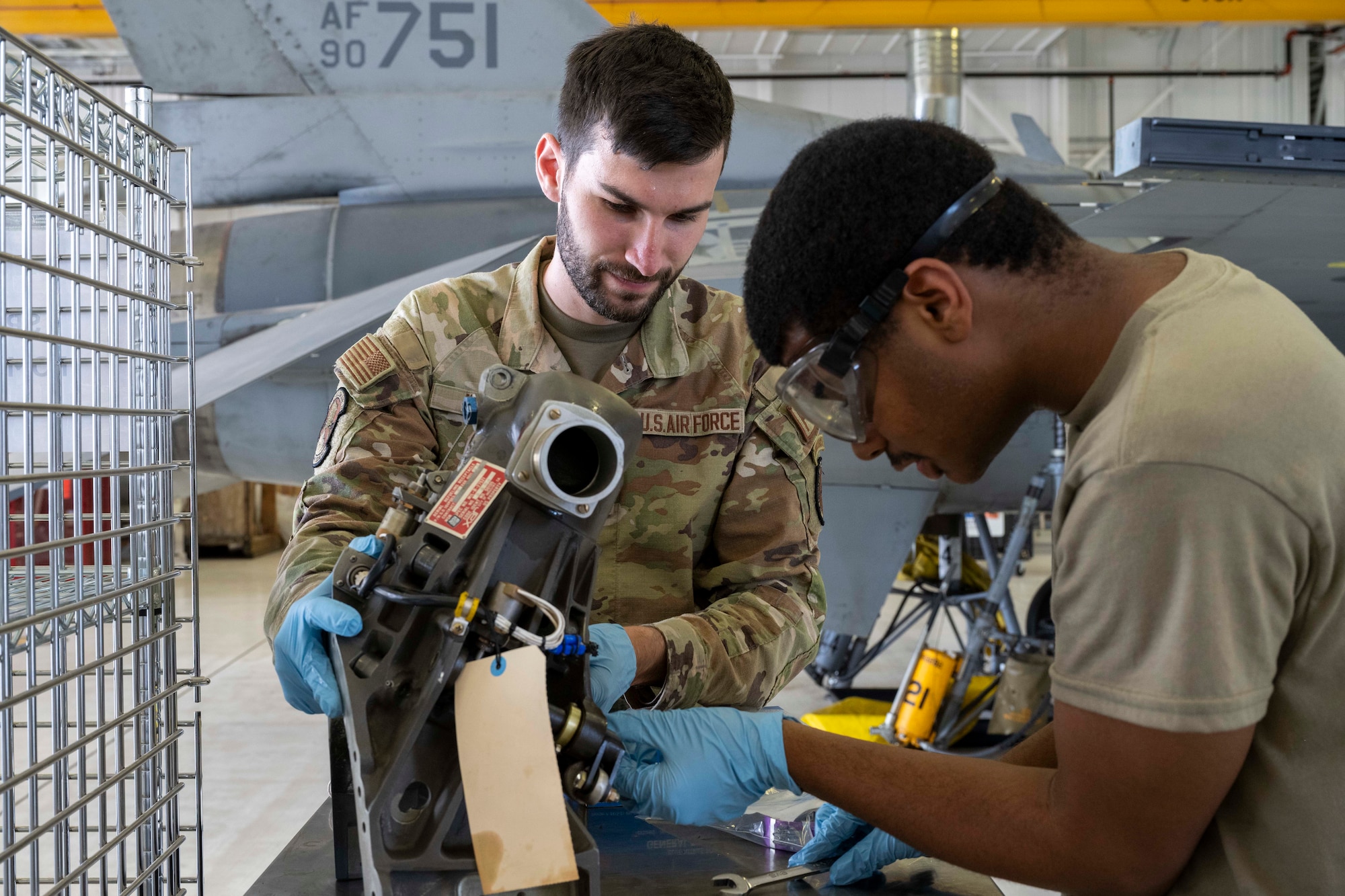 U.S. Air Force Staff Sgt. Joshua White, 372nd Training Squadron Detachment 25 aircraft fuels system technician, left, and U.S. Air Force Airman 1st Class Ojani Auguste, 49th Component Maintenance Squadron fuels systems apprentice, works on an F-16 Viper part at Holloman Air Force Base, New Mexico, Aug. 6, 2024.