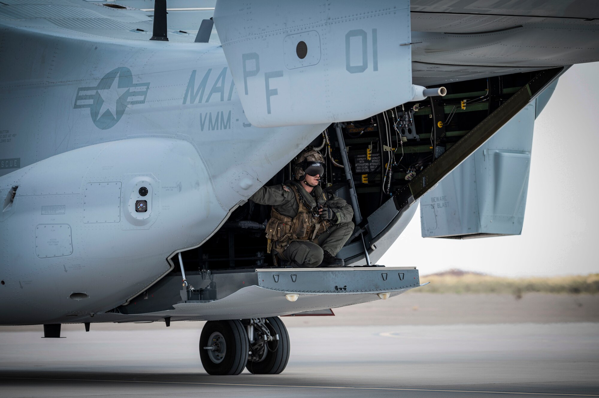U.S. Marine Corps Cpl. Treyton Olney, Marine Medium Tiltrotor Squadron 364 crew chief, sits on the ramp of an MV-22 Osprey at Holloman Air Force Base, New Mexico, July 15, 2024. During their visit to the 6th Attack Squadron, Marines from HMLA-267 and VMM-364, based at Marine Corps Air Station Camp Pendleton, Calif. witnessed the MQ-9 Reaper precision strike capabilities while demonstrating the capabilities of their respective aircraft. (U.S. Air Force photo by Senior Airman Isaiah Pedrazzini)
