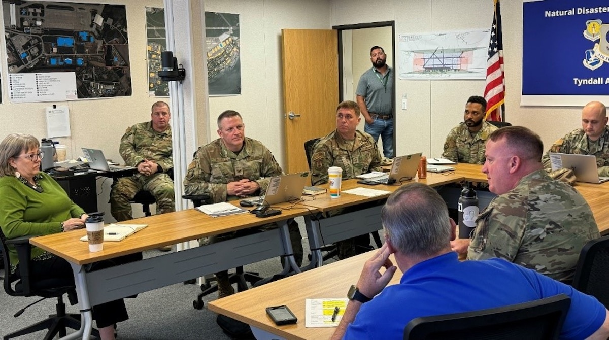 A group of Airmen and civilians meeting in a conference room