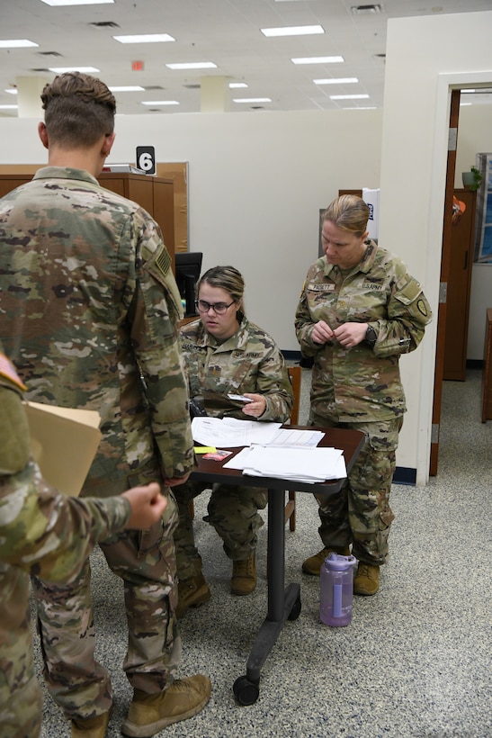 Maj. Jeanette Padgett, pictured right, human resources officer in charge, 297th Regional Support Group, Alaska Army National Guard, assists 2nd Lt. Samantha Hambrick, a human resources officer also with 297th RSG, with managing the tactical personnel system at the Soldier Readiness Processing site during Mobilization Exercise (MOBEX) III held at Camp Funston on Fort Riley, Kansas, Aug. 6, 2024.