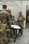 Maj. Jeanette Padgett, pictured right, human resources officer in charge, 297th Regional Support Group, Alaska Army National Guard, assists 2nd Lt. Samantha Hambrick, a human resources officer also with 297th RSG, with managing the tactical personnel system at the Soldier Readiness Processing site during Mobilization Exercise (MOBEX) III held at Camp Funston on Fort Riley, Kansas, Aug. 6, 2024.