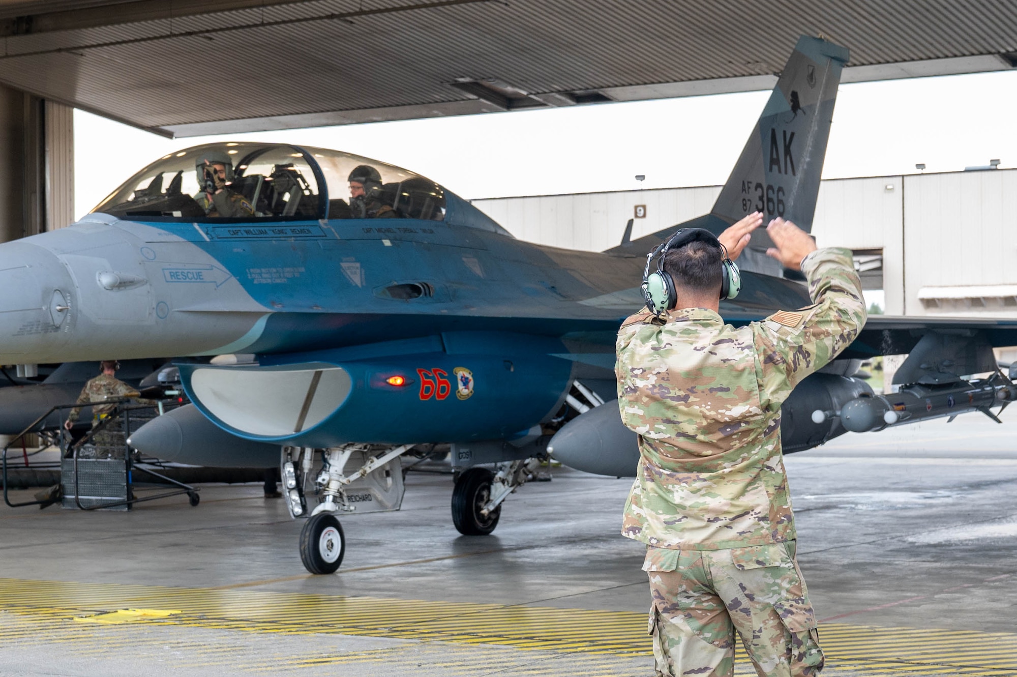 Senior Airman Daniel Macomber, 18th Fighter Generation Squadron dedicated crew chief, marshals Maj. Daniel Rule, 18th Fighter Interceptor Squadron F-16 Fighting Falcon pilot, and Gen. Gregory Guillot, Commander, North American Aerospace Defense Command and U.S. Northern Command, prior to takeoff, at Eielson Air Force Base, Alaska, Aug. 8, 2024.