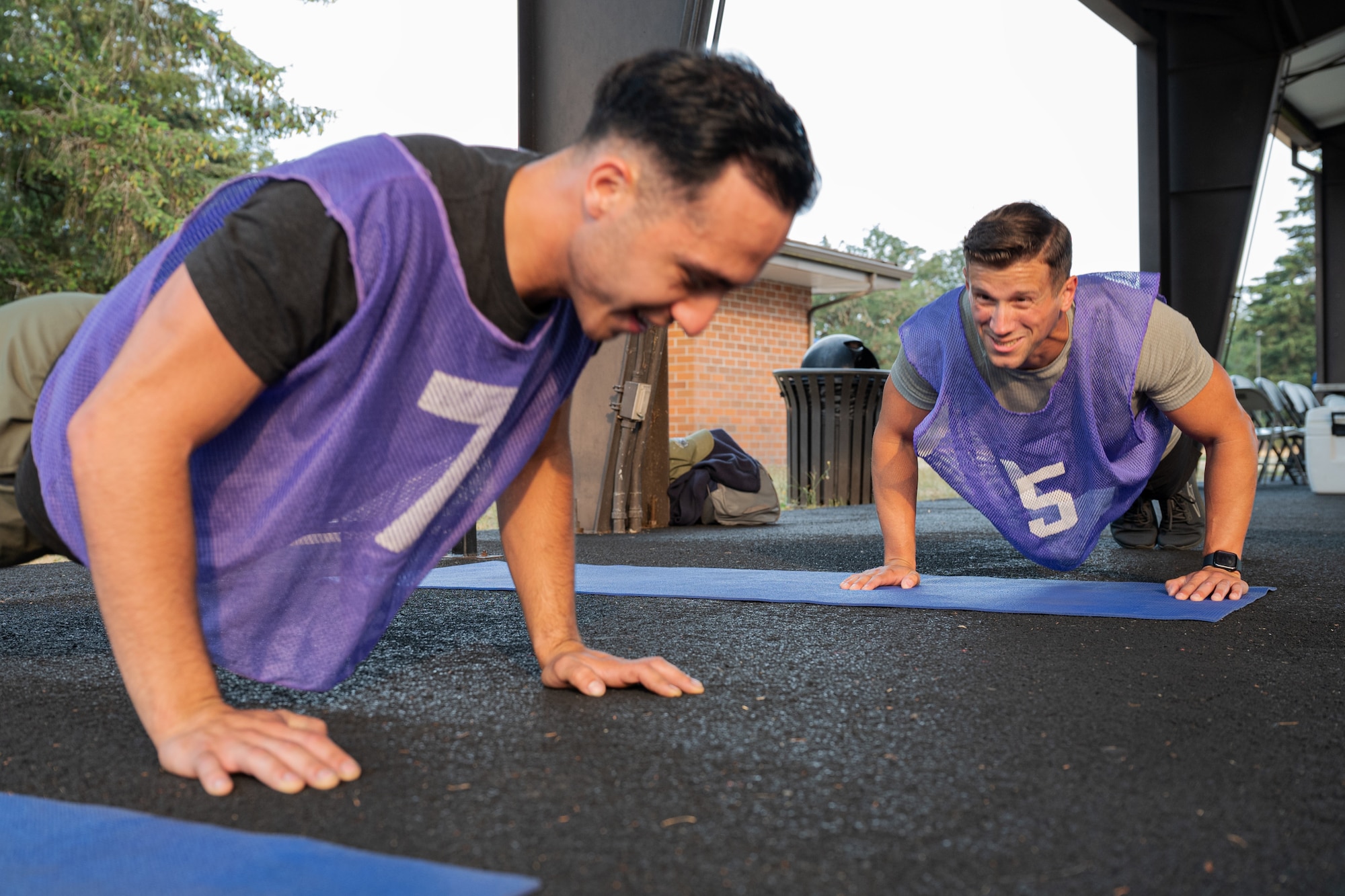 U.S. Air Force Airman 1st Class Deon Duran, hydraulics systems specialist, left, and Senior Airman James Ginez, aerospace propulsion specialist, both with the 62d Maintenance Squadron, complete push-ups for the Dash for Danielle Memorial Run at Joint Base Lewis-McChord, Washington, Aug. 9, 2024.