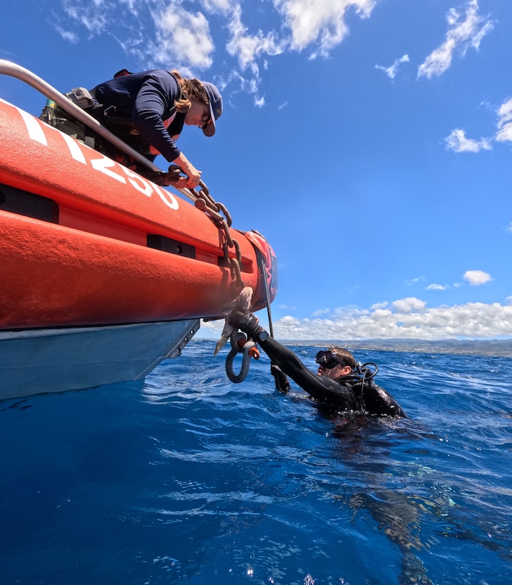 U.S. Coast Guard Diver 1st Class Kirsten Allen, Regional Dive Locker West, hands over a chain to Diver 2nd Class Tucker Younge, Regional Dive Locker West, to shackle into a sunken buoy during a recovery training exercise with the Republic of Korea Navy Underwater Construction Team divers off the coast of Oahu, Hawaii, July 17, during Exercise Rim of the Pacific (RIMPAC) 2024. Twenty-nine nations, 40 surface ships, three submarines, 14 national land forces, more than 150 aircraft, and 25,000 personnel are participating in Exercise Rim of the Pacific (RIMPAC) 2024 in and around the Hawaiian Islands, June 27 to Aug. 1. The world's largest international maritime exercise, RIMPAC provides a unique training opportunity while fostering and sustaining cooperative relationships among participants critical to ensuring the safety of sea lanes and security on the world's oceans. RIMPAC 2024 is the 29th exercise in the series that began in 1971. (U.S. Navy photo by Chief Mass Communication Specialist Kathleen Gorby)