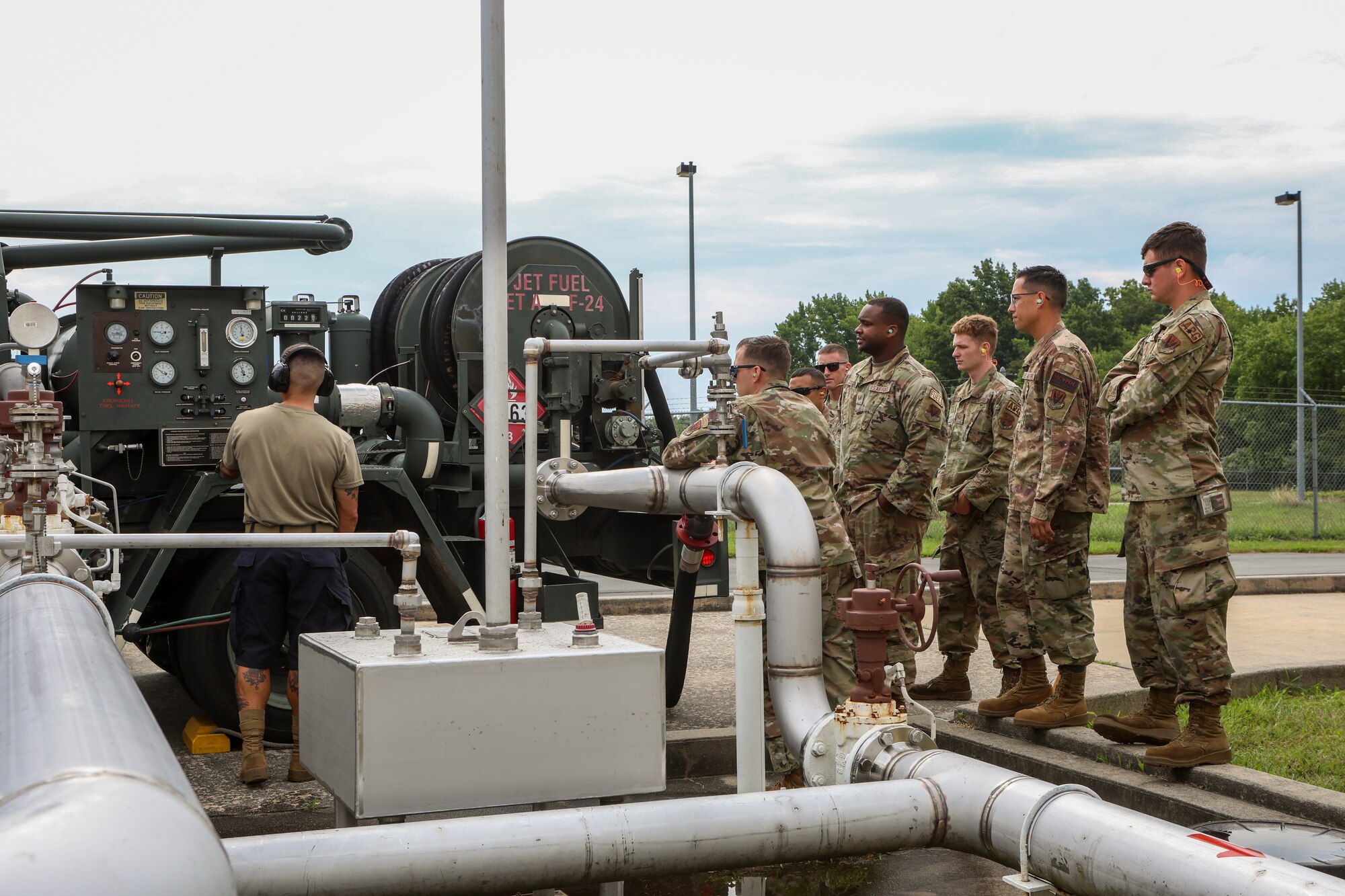 A photo of 177th Logistics Readiness Squadron petroleum, oils and lubricants fuel management flight technicians standing near an instructor giving a demonstration of an R-12 hydrant servicing vehicle on Joint Base McGuire-Dix-Lakehurst.