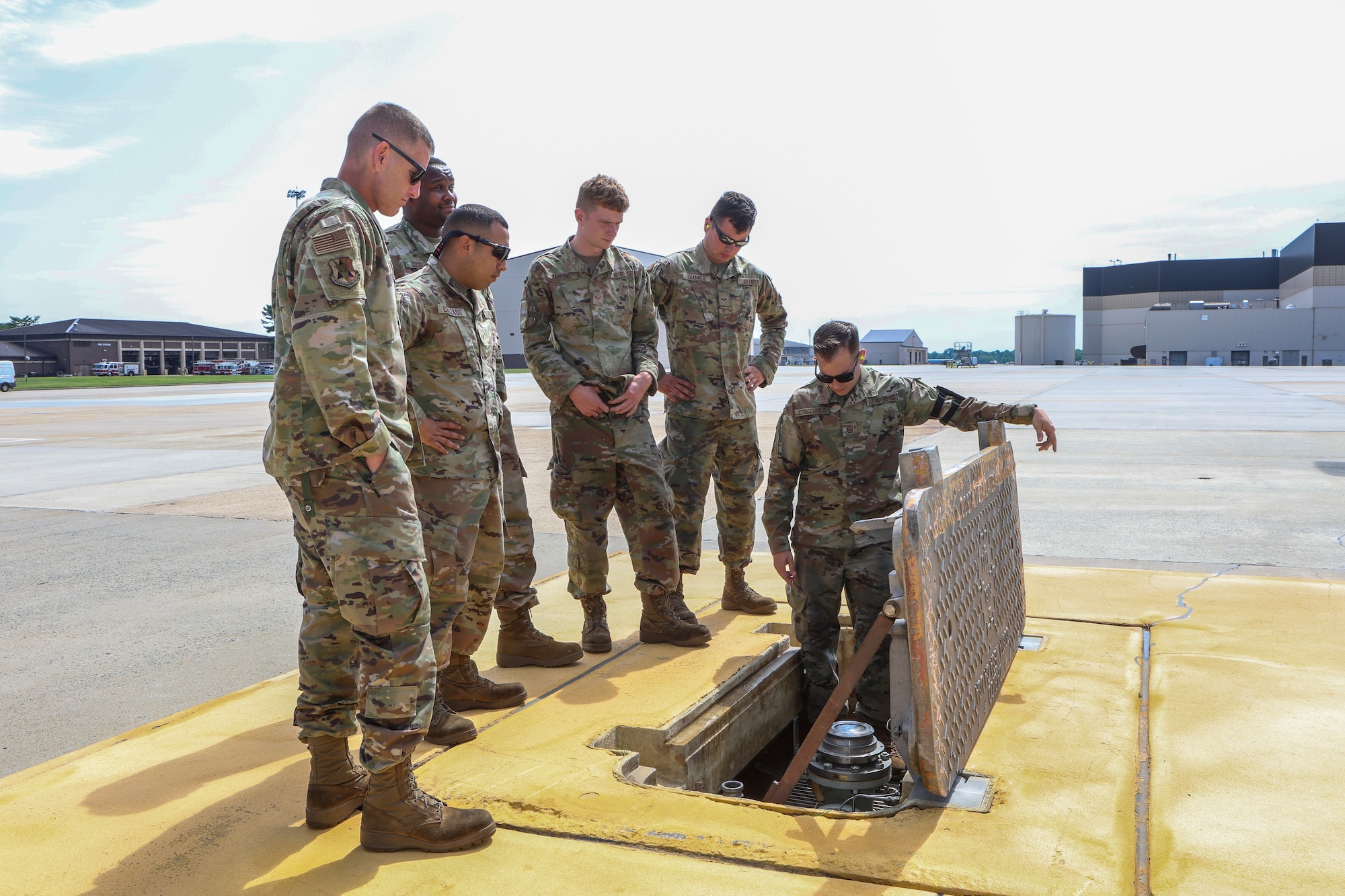 A photo of 177th Logistics Readiness Squadron petroleum, oils and lubricants fuel management flight technicians standing near an instructor giving a demonstration on the flight line of Joint Base McGuire-Dix-Lakehurst.