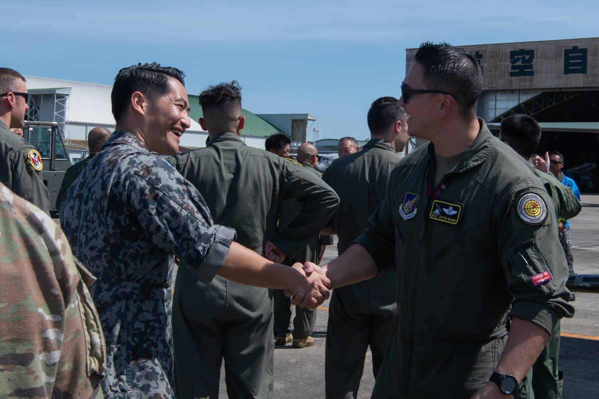 Japan Air Self-Defense Force members assigned to the 401st Tactical Airlift Squadron greet U.S. Air Force Airmen.