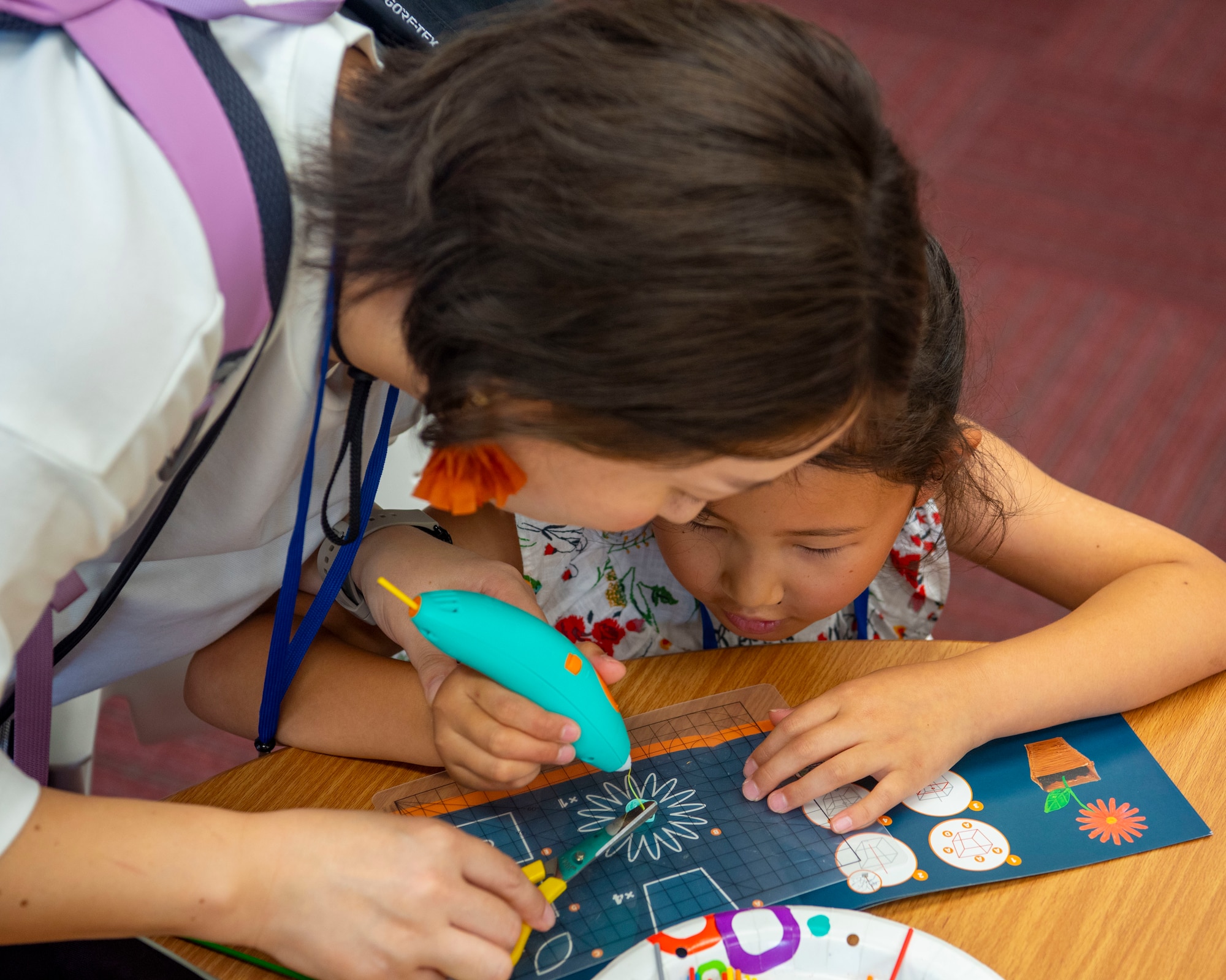 A young participant focuses on their 3D art while their mom helps during a Misawa Friendship Tour at Misawa Air Base, Japan, Aug. 2, 2024.