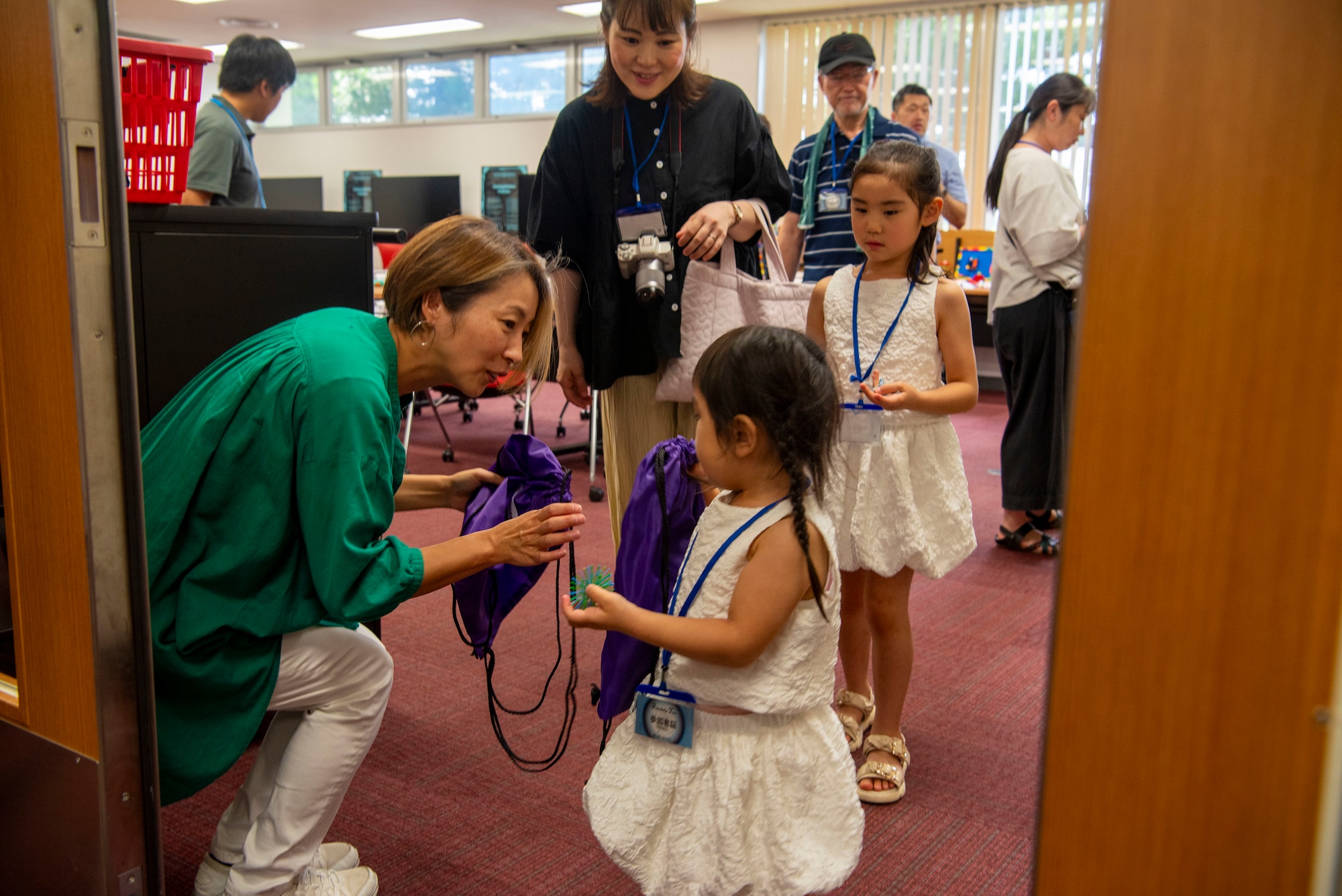 Asako Tuttle, left, 35th Force Support Squadron library director, hands a gift bag to a participant during a Misawa Friendship Tour at Misawa Air Base, Japan, Aug. 2, 2024.